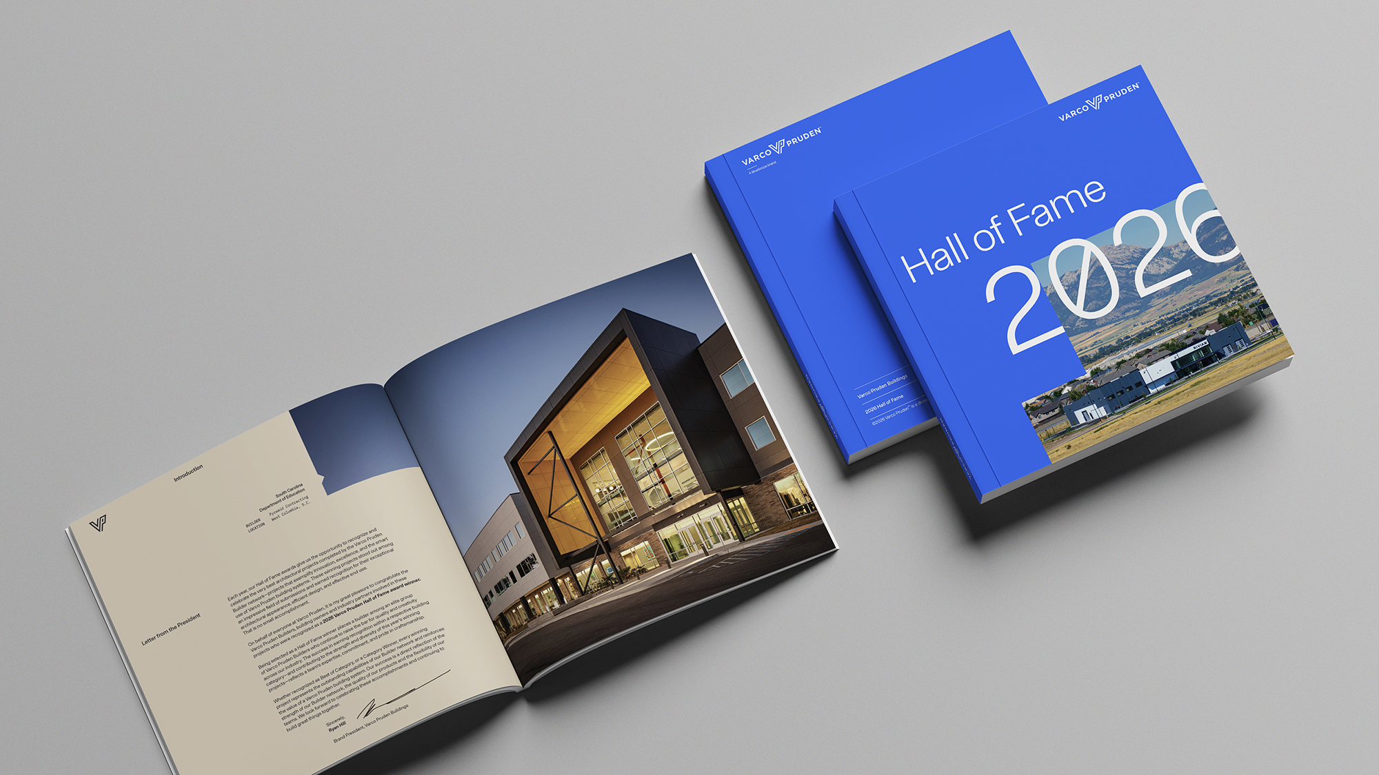 Open Hall of Fame publication featuring a contemporary building project alongside stacked blue award books on a clean studio background.