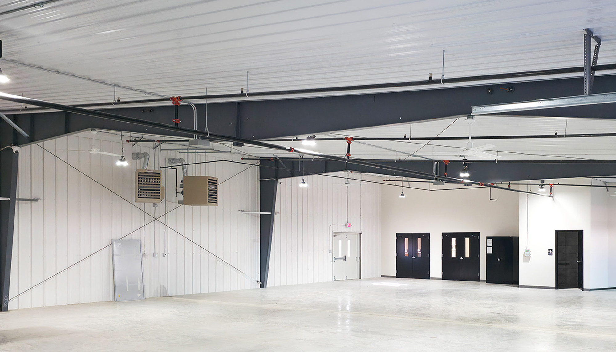 Open industrial interior with exposed steel framing, insulated wall panels and flexible clear-span floor space designed for multi-purpose operations.