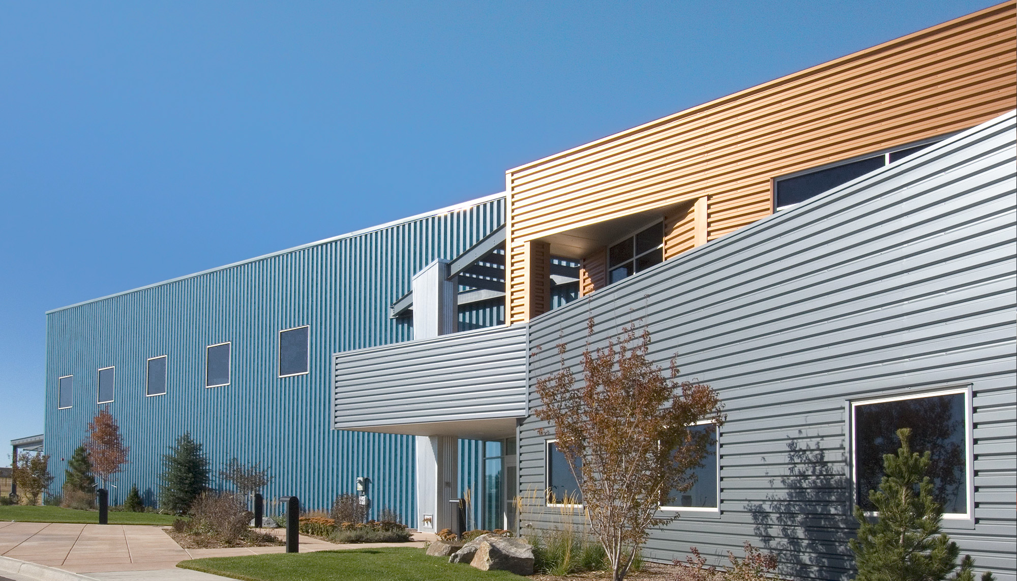 Modern metal building exterior with blue and silver panel cladding and contemporary architectural design.
