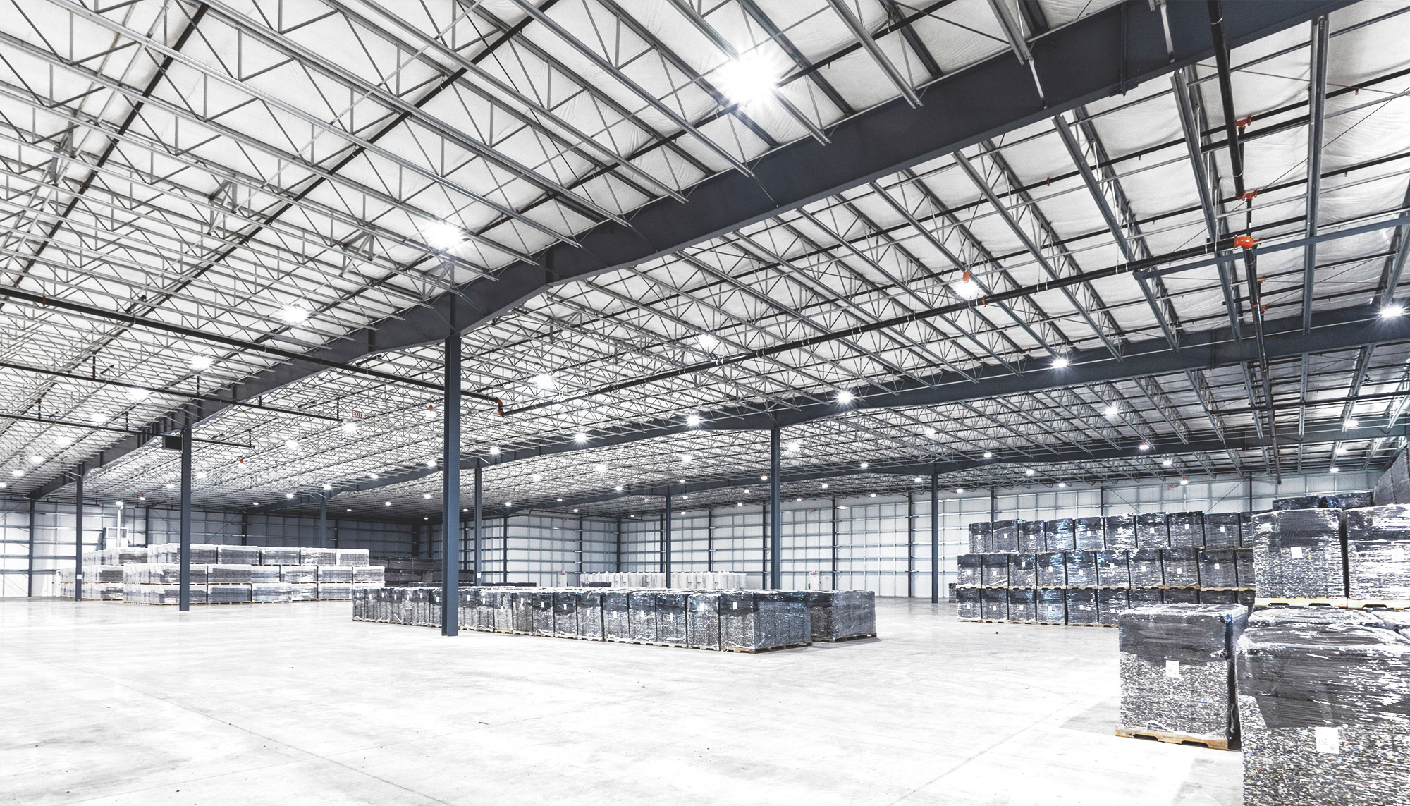 Expansive warehouse interior with exposed steel framing, high-bay ceiling system and open distribution floor designed for large-scale industrial operations.