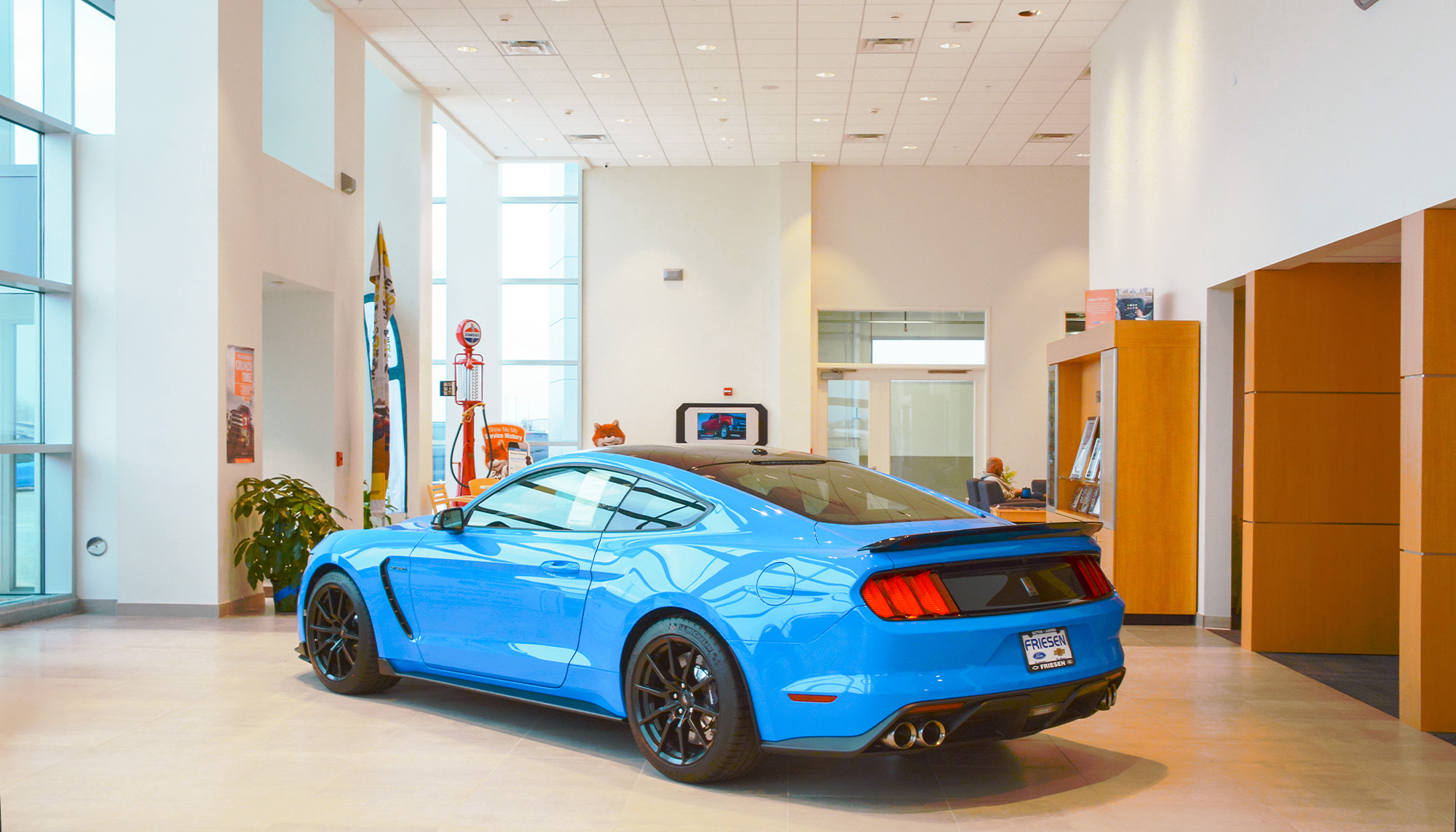 Automotive showroom interior with performance vehicle, high ceilings and modern commercial steel building design.