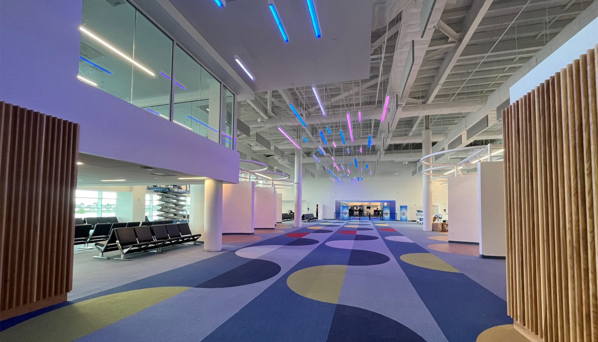 Cruise terminal interior featuring passenger waiting area, open concourse design and steel-framed transportation facility construction.