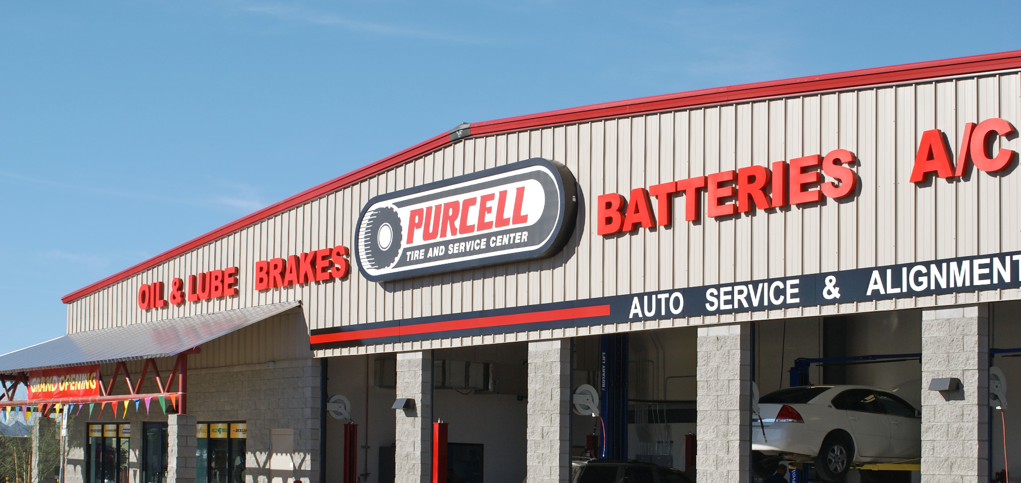 Purcell Tire and Service Center featuring a metal-paneled exterior, prominent signage and multiple automotive service bays, demonstrating steel building solutions for commercial automotive facilities.
