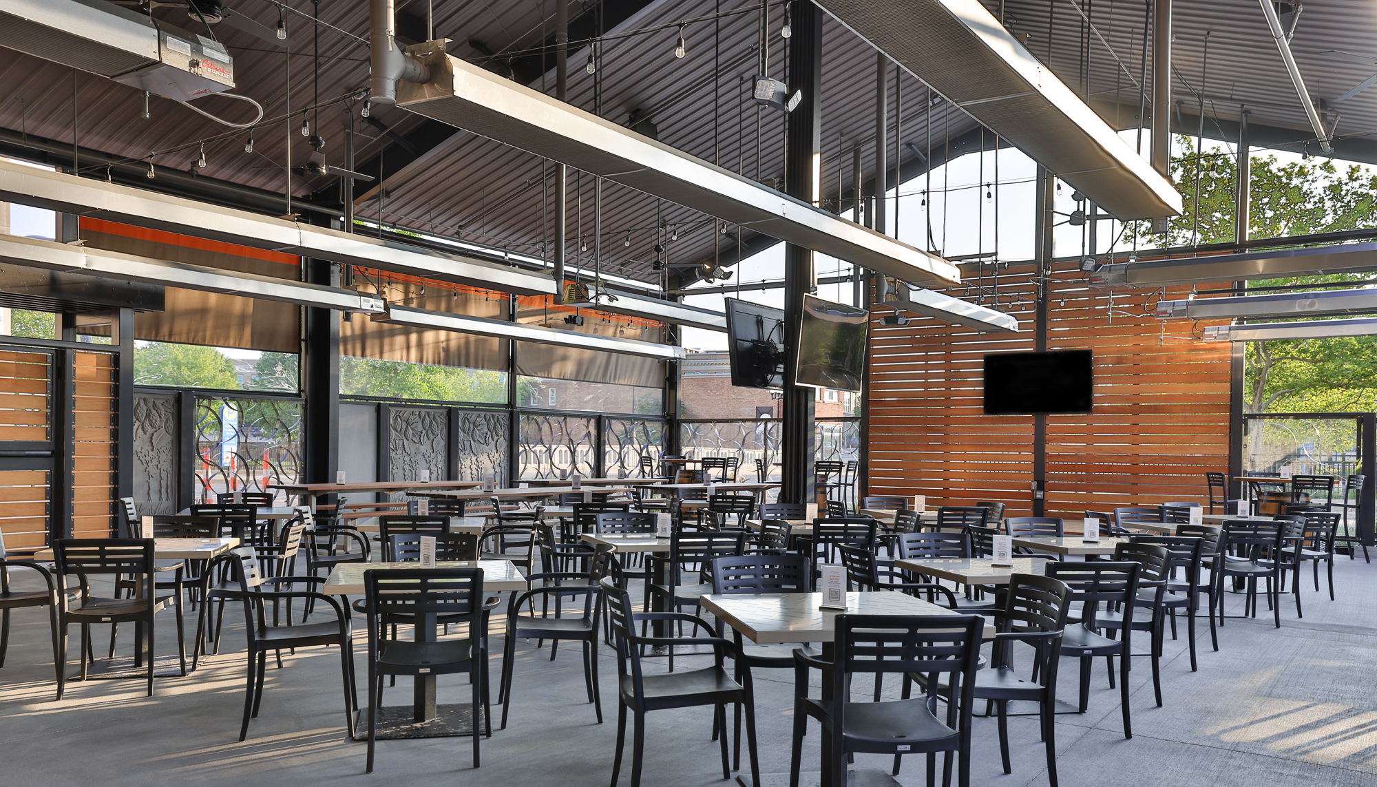 Interior dining and gathering space at the New Holland Brewing Co. beer garden featuring integrated indoor-outdoor seating, flexible hospitality environments and coordinated design developed to support year-round entertainment and community engagement.
