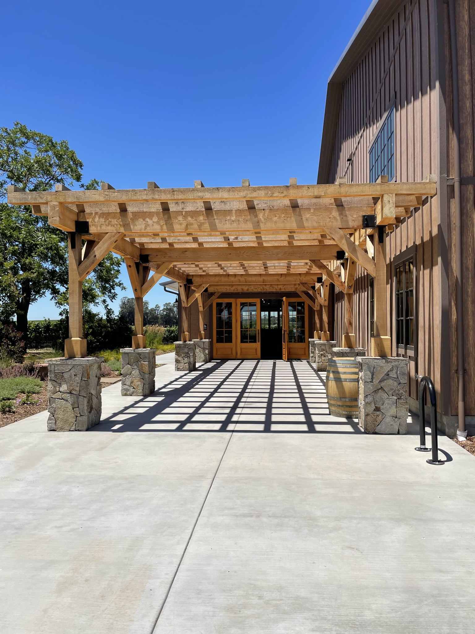 Commercial winery building entrance with covered outdoor walkway, steel building construction and architectural wood accents.