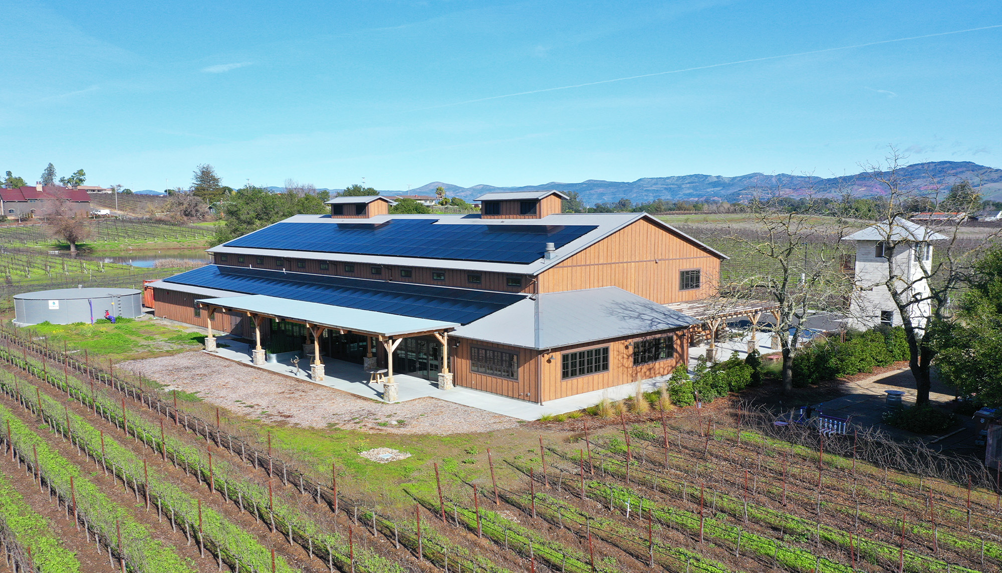 Winery facility featuring metal building construction, standing seam roof system and vineyard production operations.
