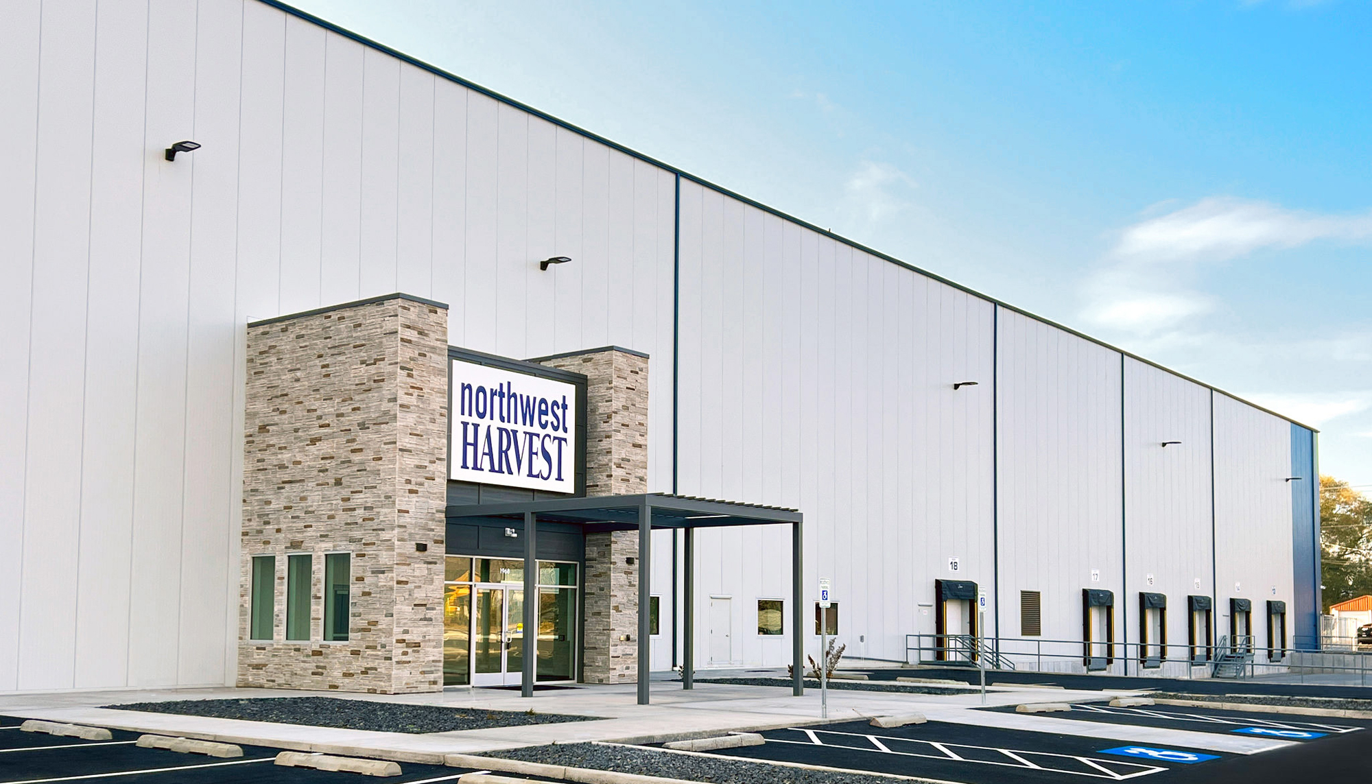 Entrance view of the Northwest Harvest Distribution Center featuring integrated loading access, large-scale distribution operations and a coordinated facility designed to improve statewide food logistics and storage capacity.