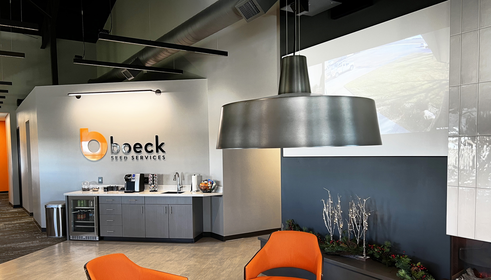 Modern office lounge and reception area featuring exposed ceilings, integrated lighting and branded interior finishes.