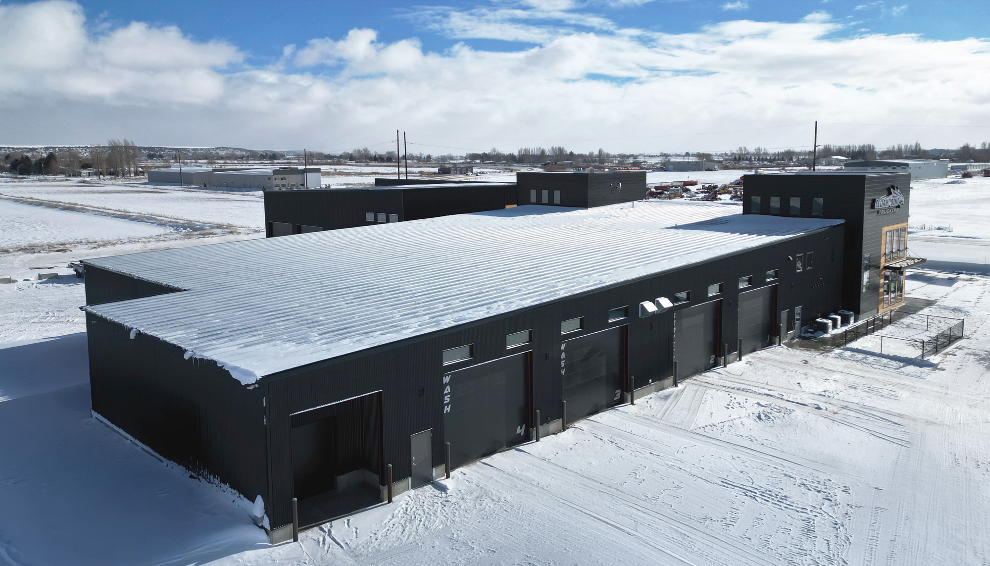 Aerial view of Cedarpoint Trucking Headquarters fleet maintenance facility with multiple service bays and metal panel exterior.