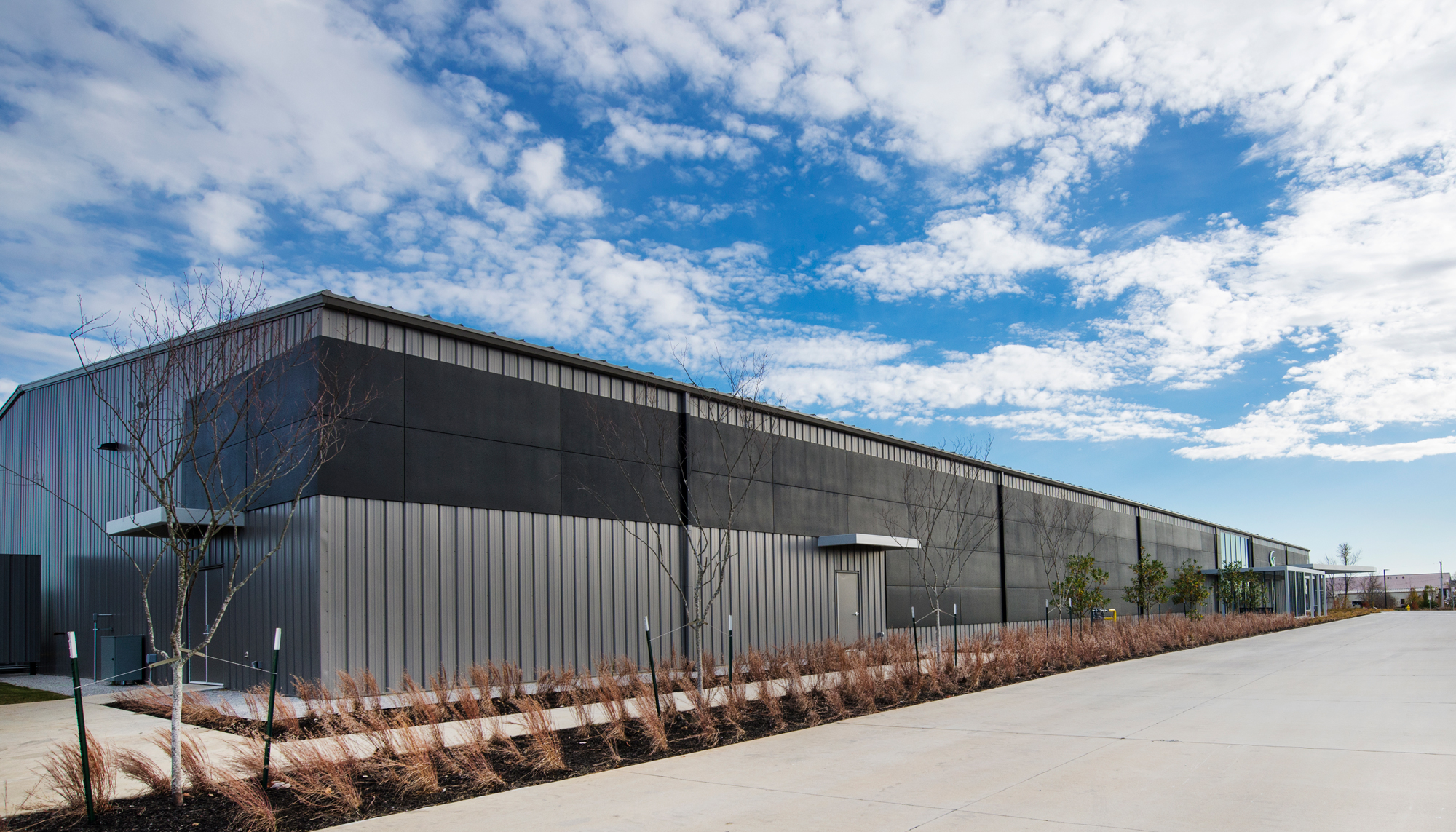 Exterior side view of the Game Aerospace facility featuring integrated aircraft manufacturing infrastructure, durable operational building systems and coordinated aviation production environments designed to support efficient workflows and future adaptability.