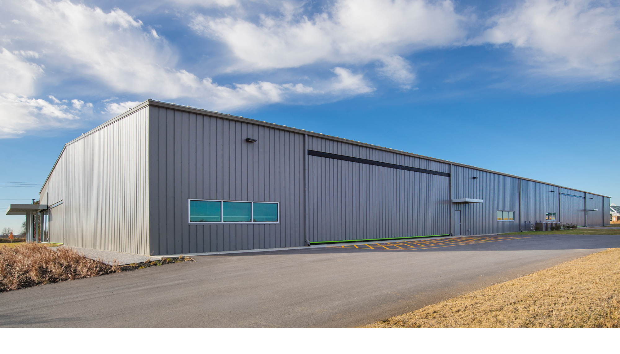 Exterior view of the Game Aerospace facility featuring expansive aircraft manufacturing space, integrated operational systems and coordinated building design developed to support efficient production workflows and specialized aviation requirements.