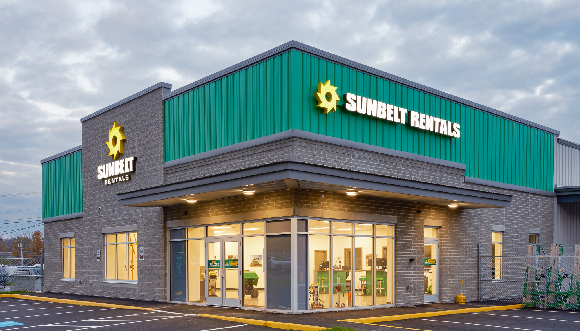 Exterior evening view of the Sunbelt Rentals facility featuring integrated sales and service operations, durable building systems and a customer-focused environment designed to support efficient equipment rental operations and a strong professional presence.