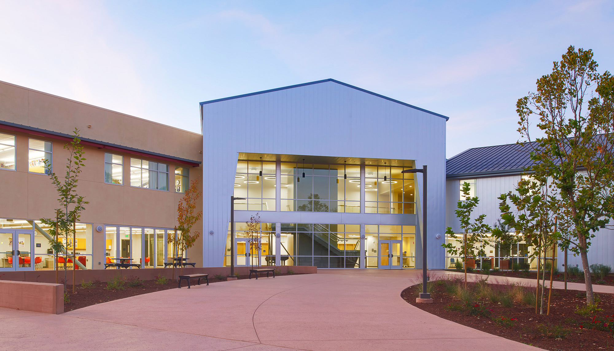 School building with expansive storefront glazing, collaborative learning spaces and modern educational facility design.