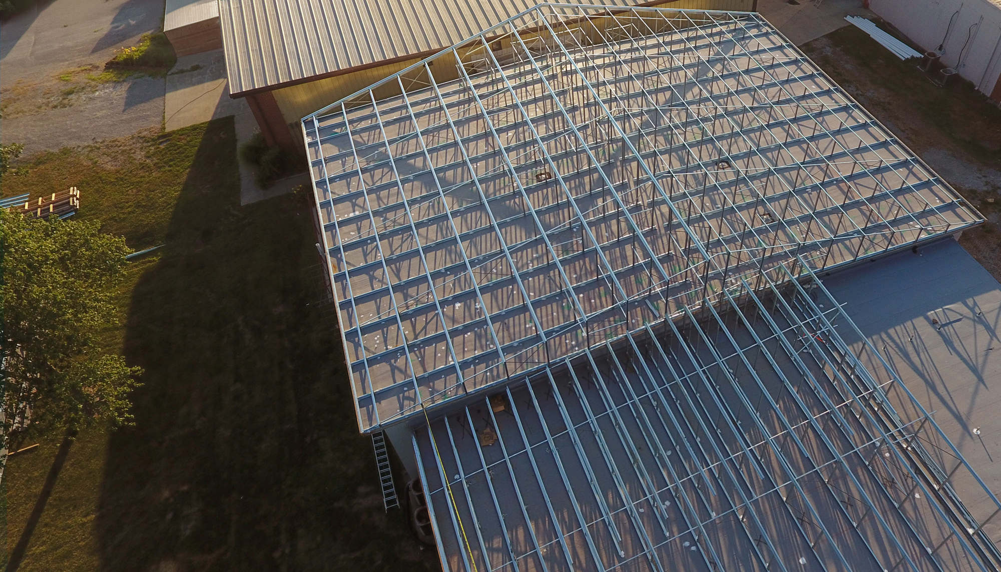 Aerial construction view of the Santa Fe Schools Roof Retrofit project featuring coordinated structural retrofit systems and phased roof installation designed to adapt to varying building conditions while maintaining ongoing school operations.