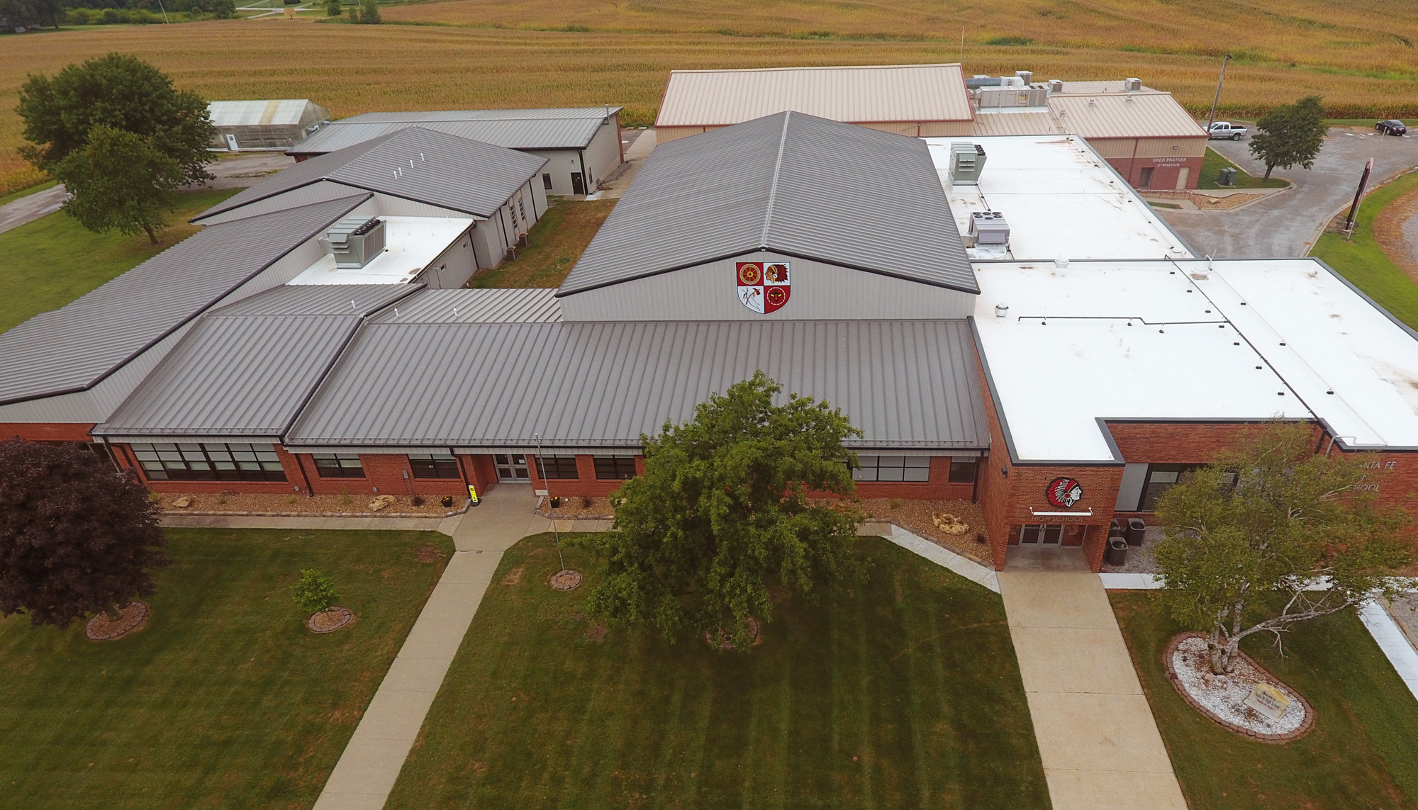 Aerial view of the Santa Fe Schools Roof Retrofit project featuring coordinated roofing systems across multiple educational facility sections designed to improve building protection, operational continuity and long-term performance under varied existing conditions.