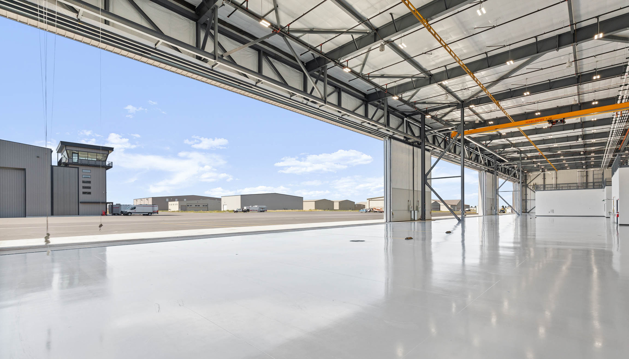 Aviation hangar with structural steel framing, aircraft service bay and pre-engineered metal building construction.