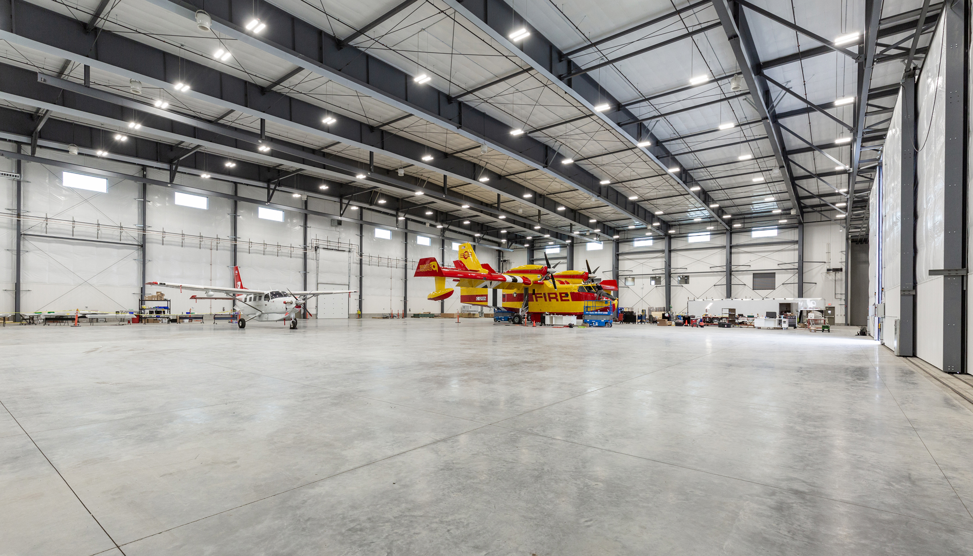 Aircraft hangar interior featuring clear span steel framing, aviation maintenance space and large-span steel building construction.