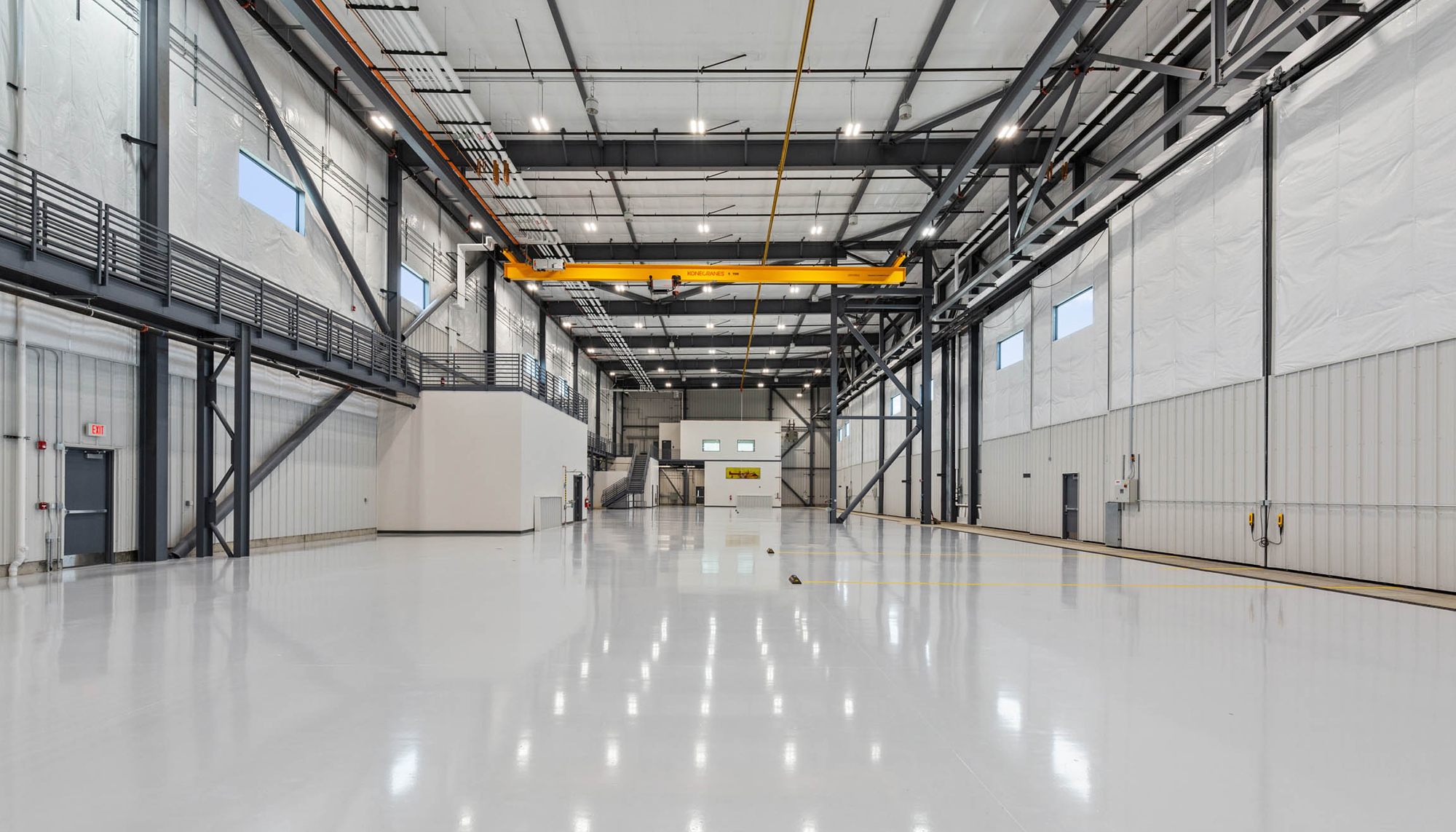 Aircraft maintenance hangar featuring clear span steel framing, overhead crane system and aviation service facility construction.
