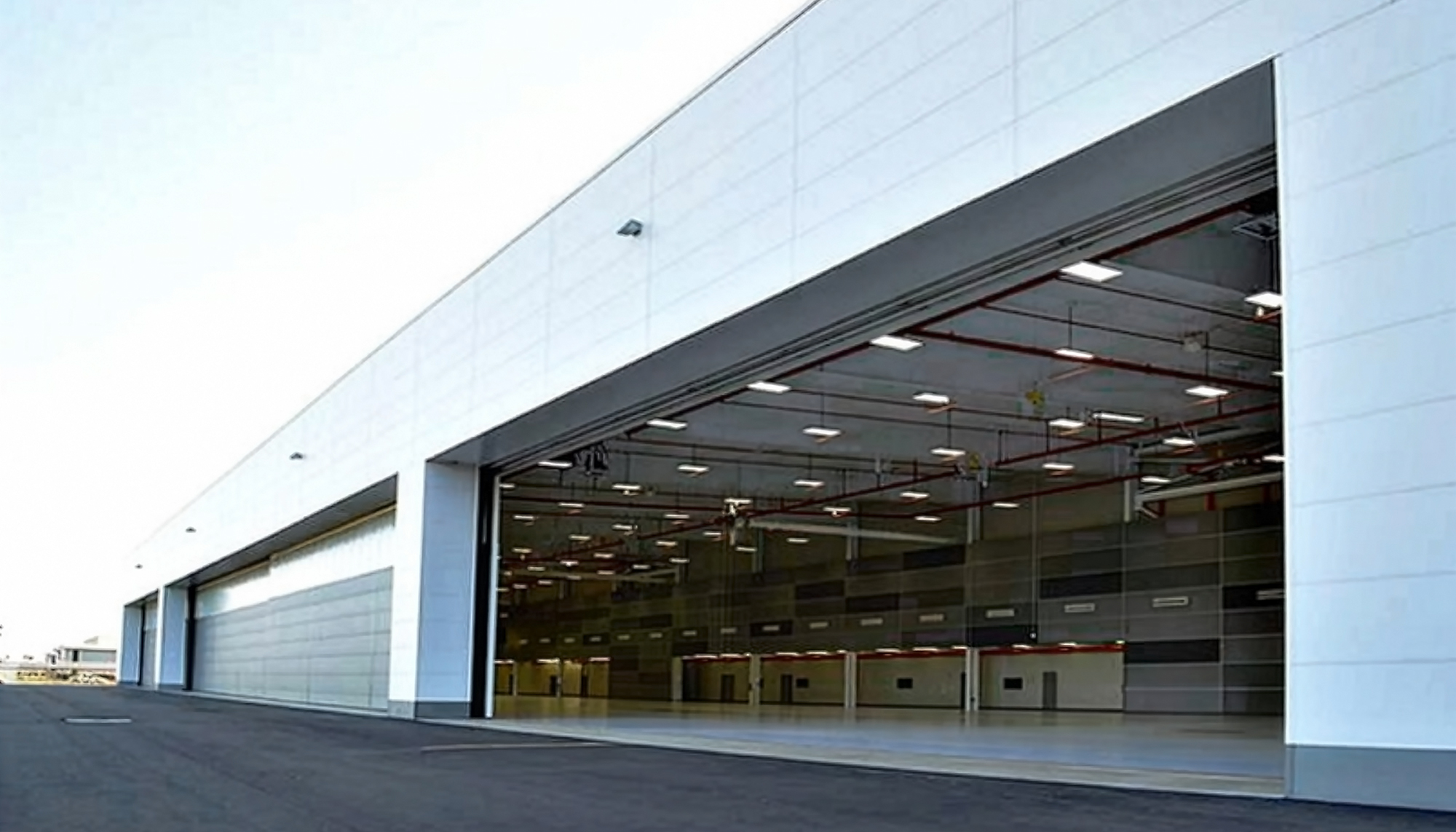 Exterior hangar entrance view of the Dassault Falcon Jet – 14 Bay Hangar featuring expansive aircraft access openings, integrated aviation support infrastructure and coordinated clear-span structural systems designed to support high-capacity aircraft operations and efficient workflow performance.