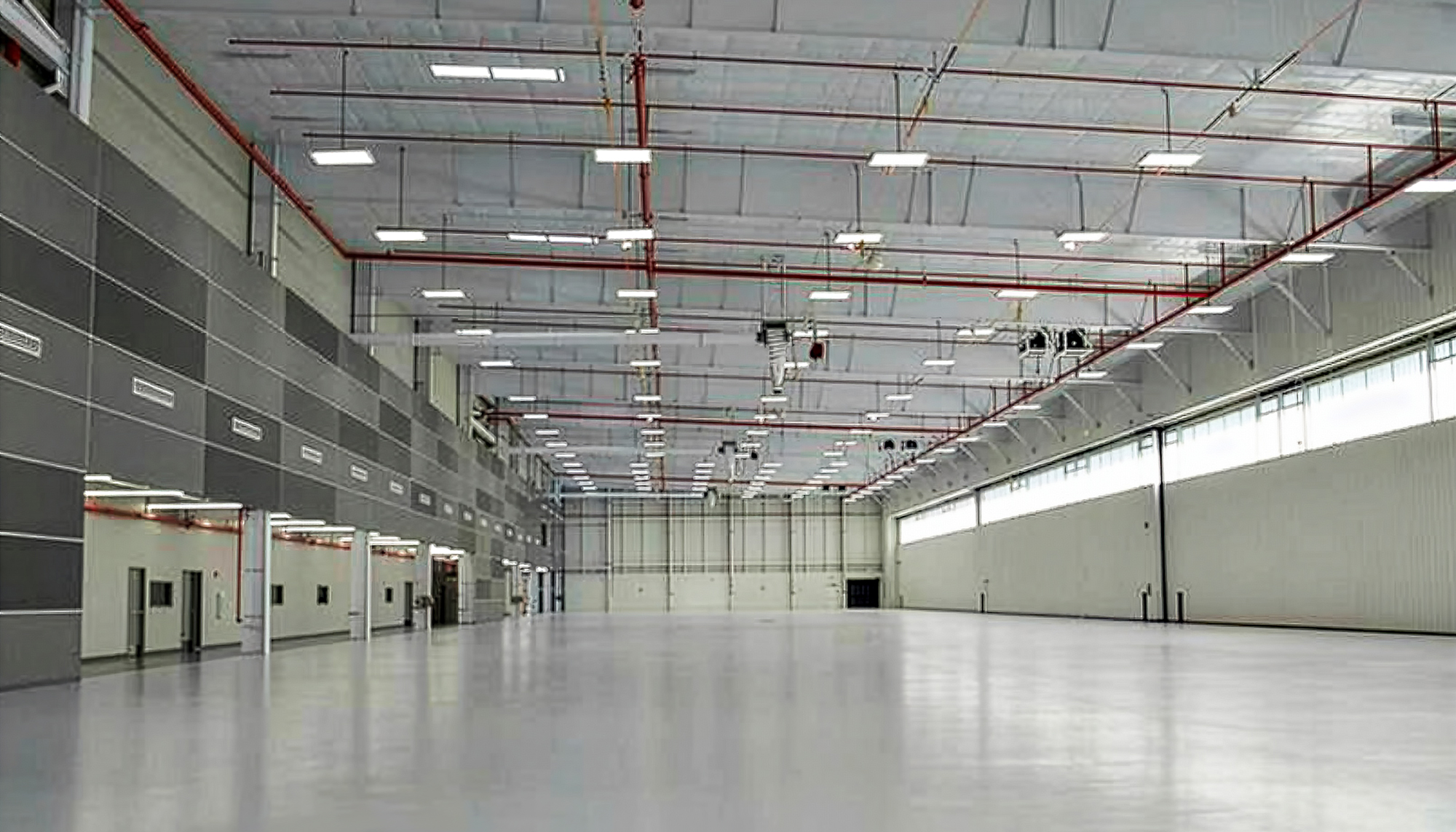Interior view of the Dassault Falcon Jet – 14 Bay Hangar featuring expansive clear-span aircraft service space, integrated aviation support systems and coordinated operational infrastructure designed to support multiple aircraft maintenance operations without structural interference.