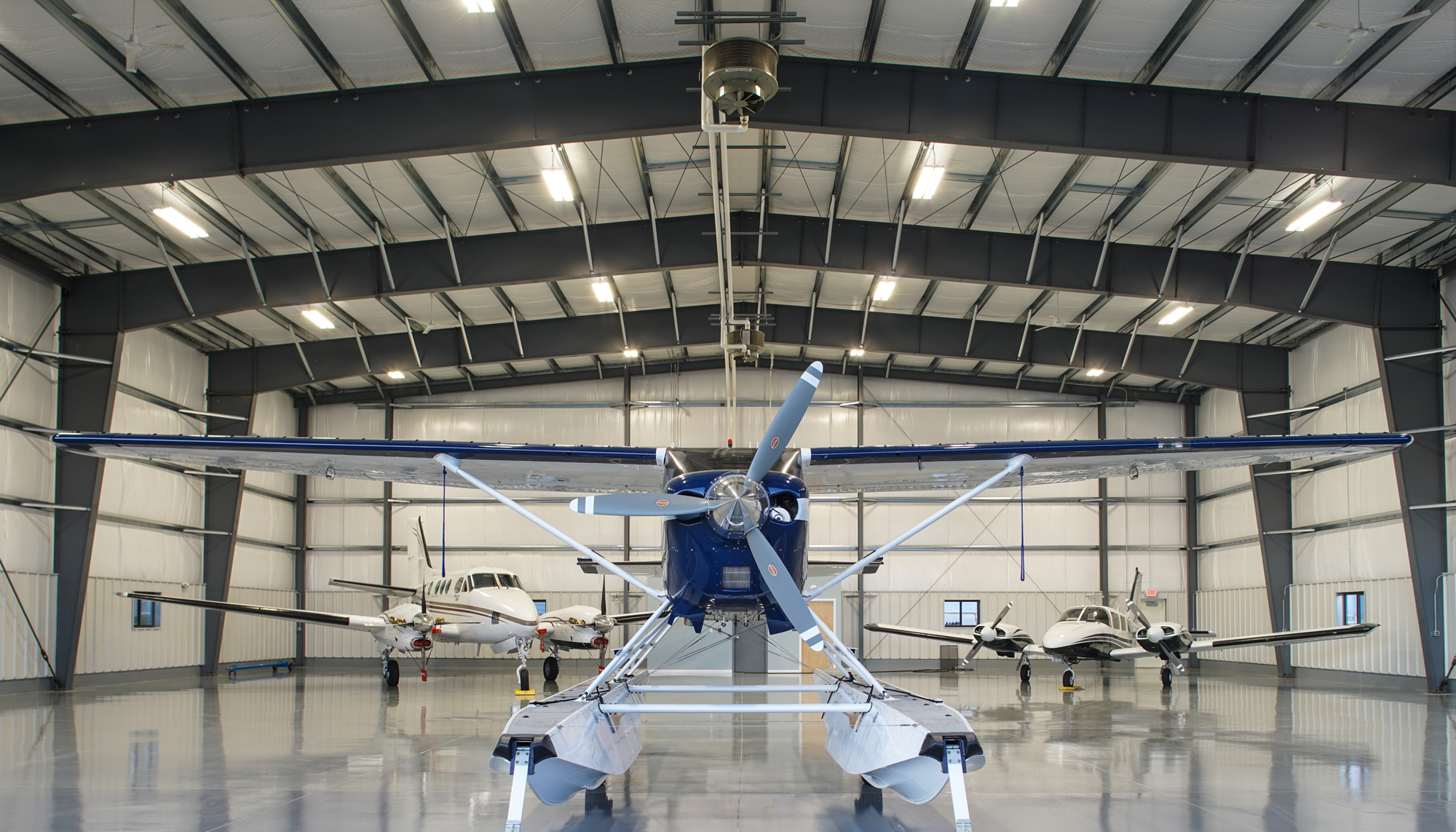 Aircraft positioned inside the Maine Instrument Flight Corporate Hangar beneath a clear-span structural system designed to support efficient aircraft movement, operational flexibility and unobstructed interior space.