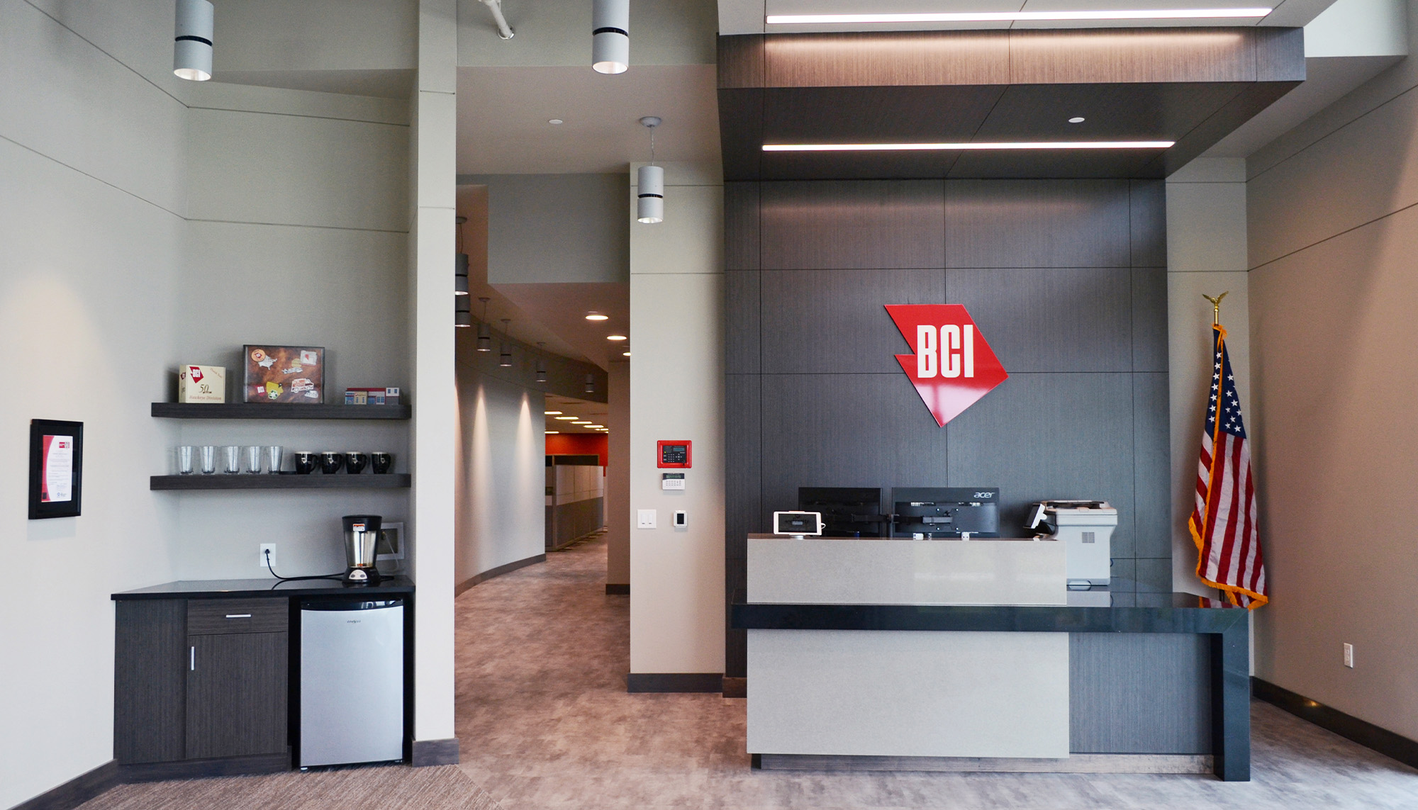 Corporate office lobby featuring reception desk, architectural interiors and commercial steel building design.