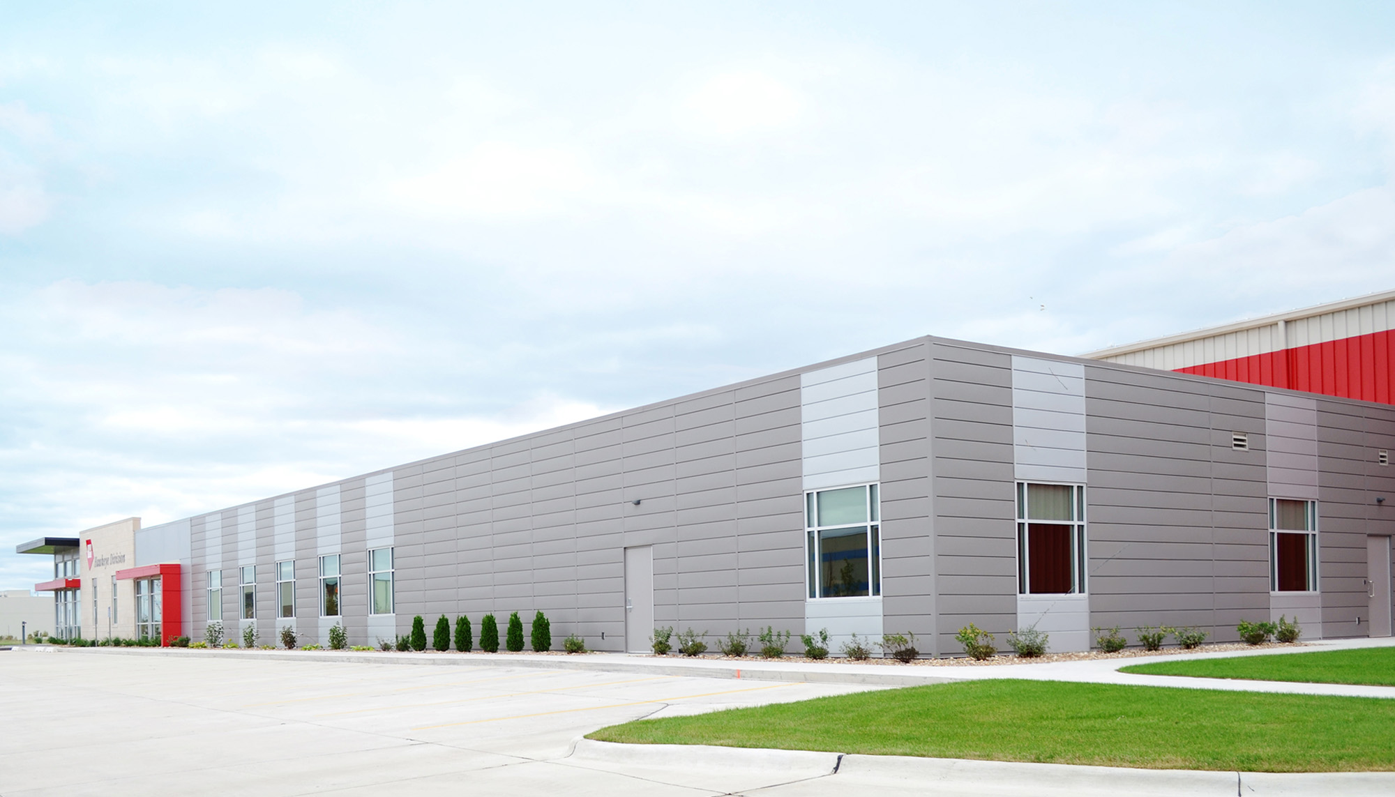 Industrial manufacturing facility featuring architectural metal wall panels, integrated office space and pre-engineered steel building construction.