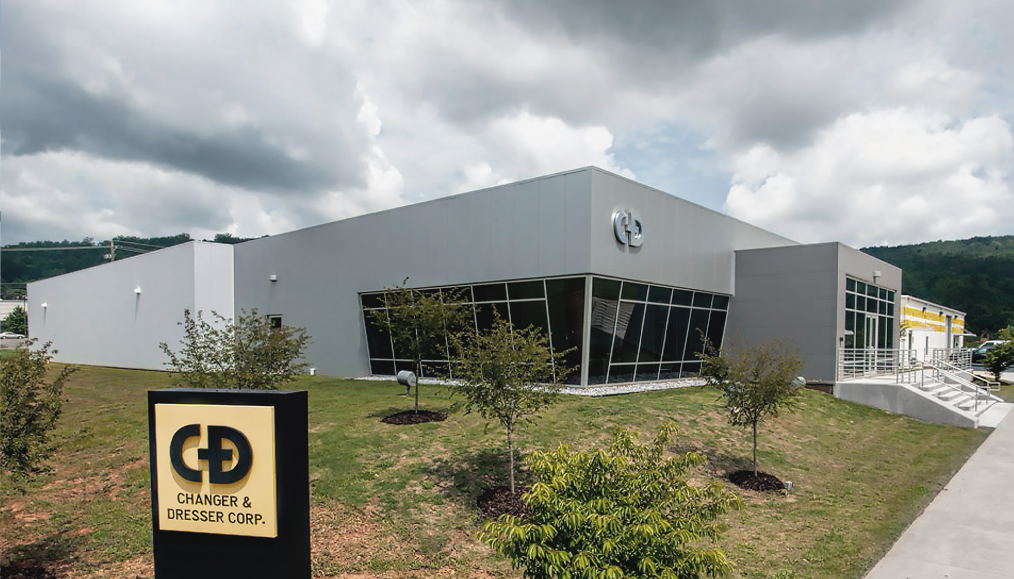 Industrial manufacturing facility with architectural metal wall panels, curtain wall glazing and steel building construction.
