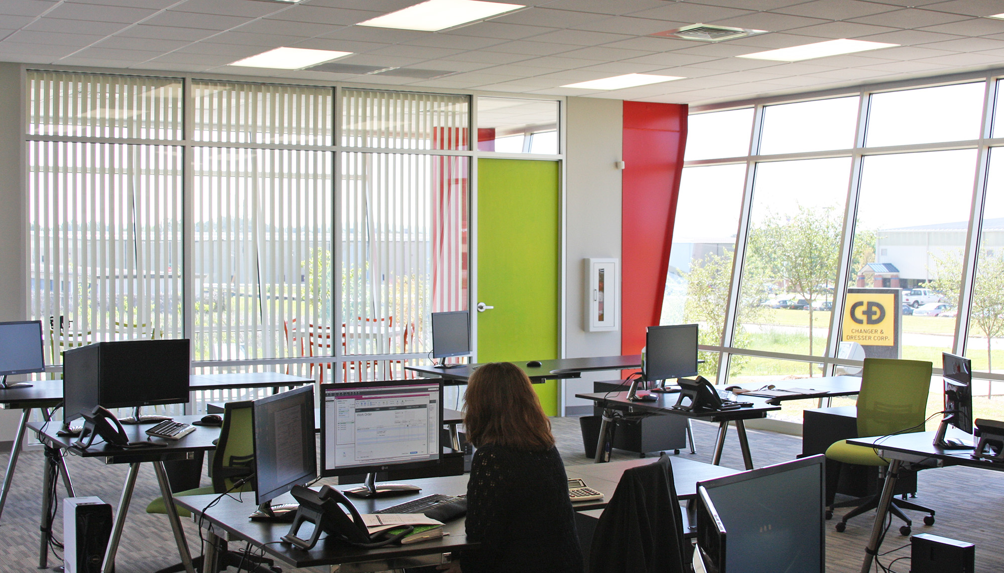 Commercial office interior featuring collaborative workstations, expansive glazing and steel building construction.