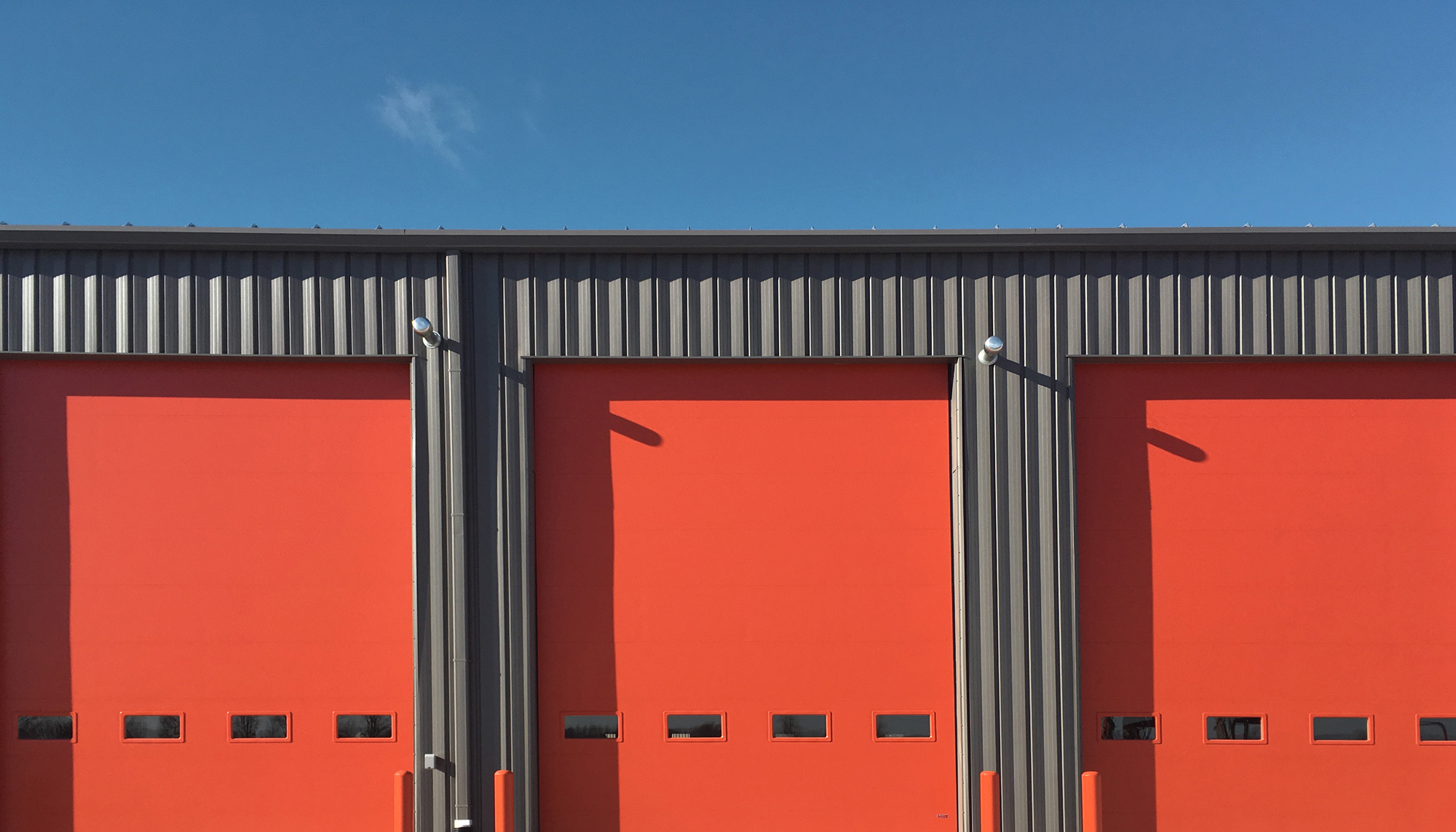 Service bay doors at the Ditch Witch of Minnesota & Iowa facility featuring durable metal panel construction.