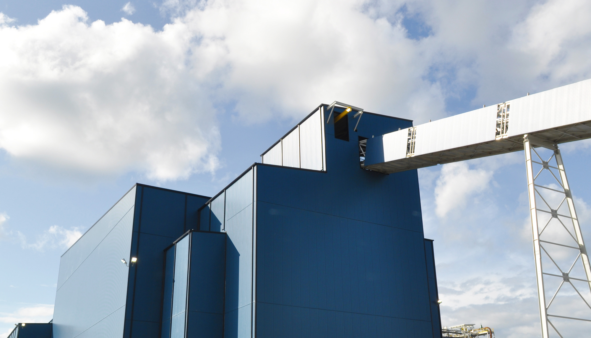 Industrial processing structures at the GreenStone Gold Mines facility featuring integrated enclosure systems and elevated material handling connections.