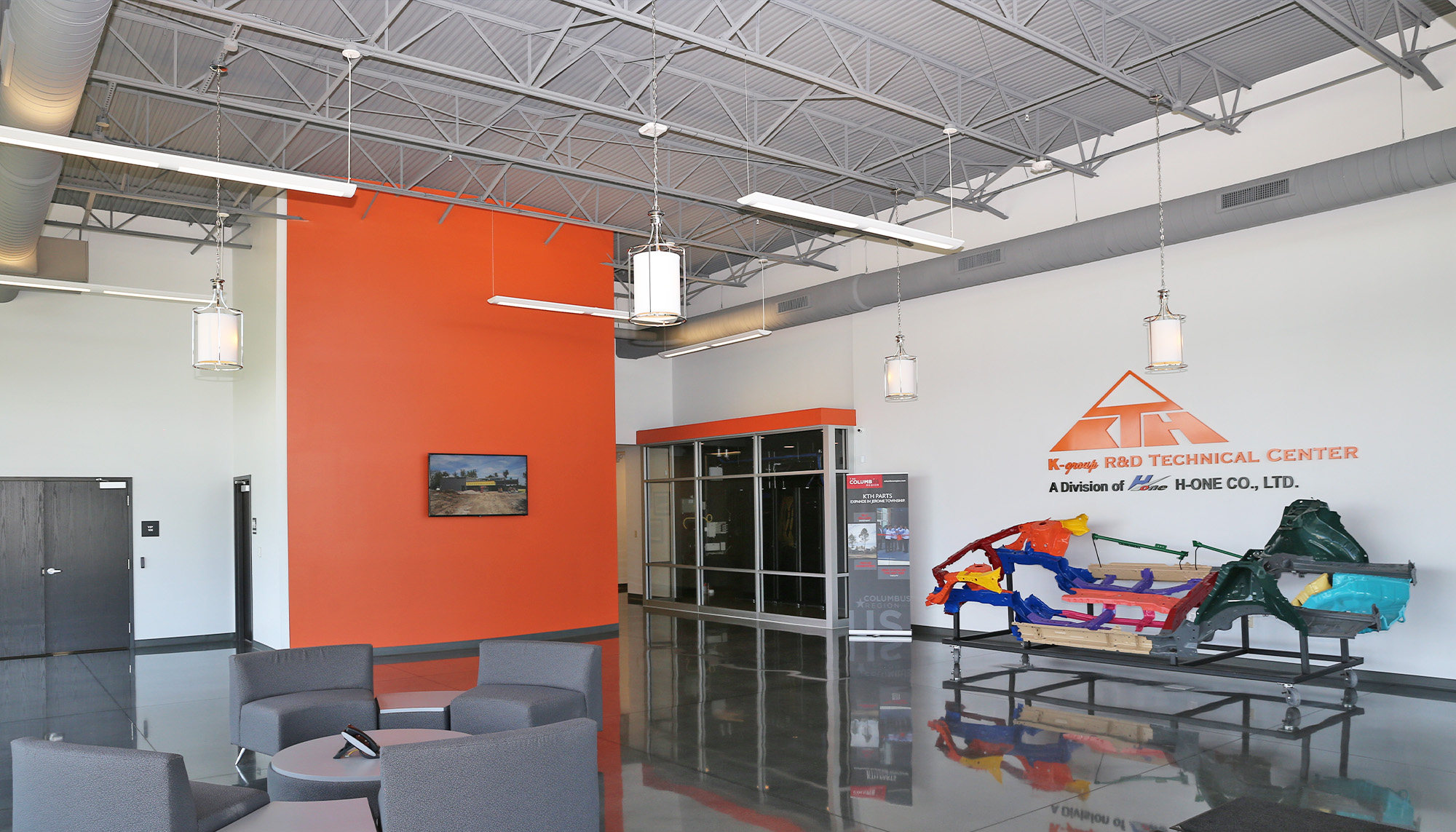 Corporate training center lobby featuring structural steel framing, open reception area and commercial office building design.