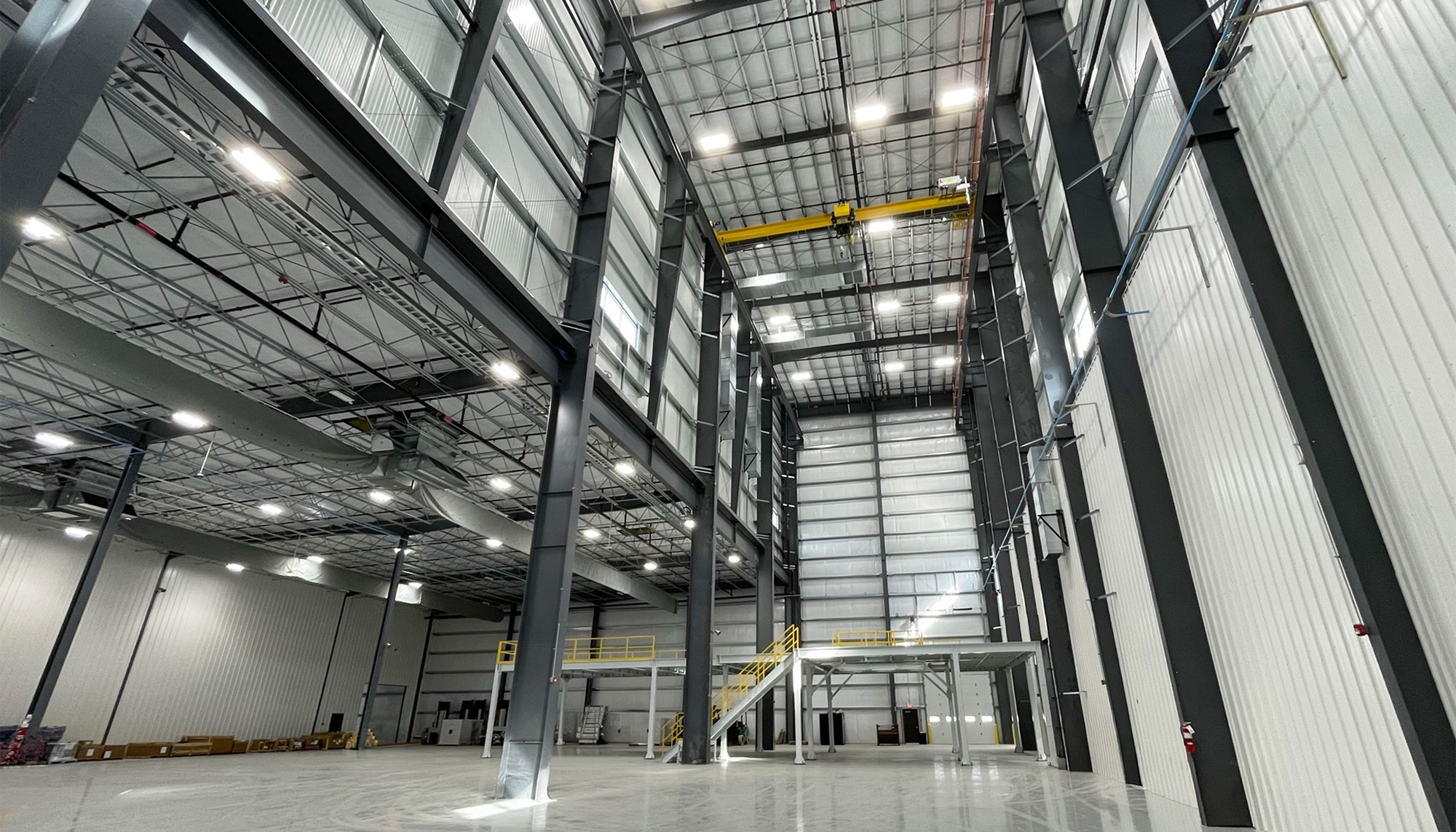 Interior high-bay manufacturing space inside the Transcendia facility featuring tall structural systems, integrated overhead crane infrastructure and coordinated production environments designed to support specialized equipment and scalable manufacturing operations.