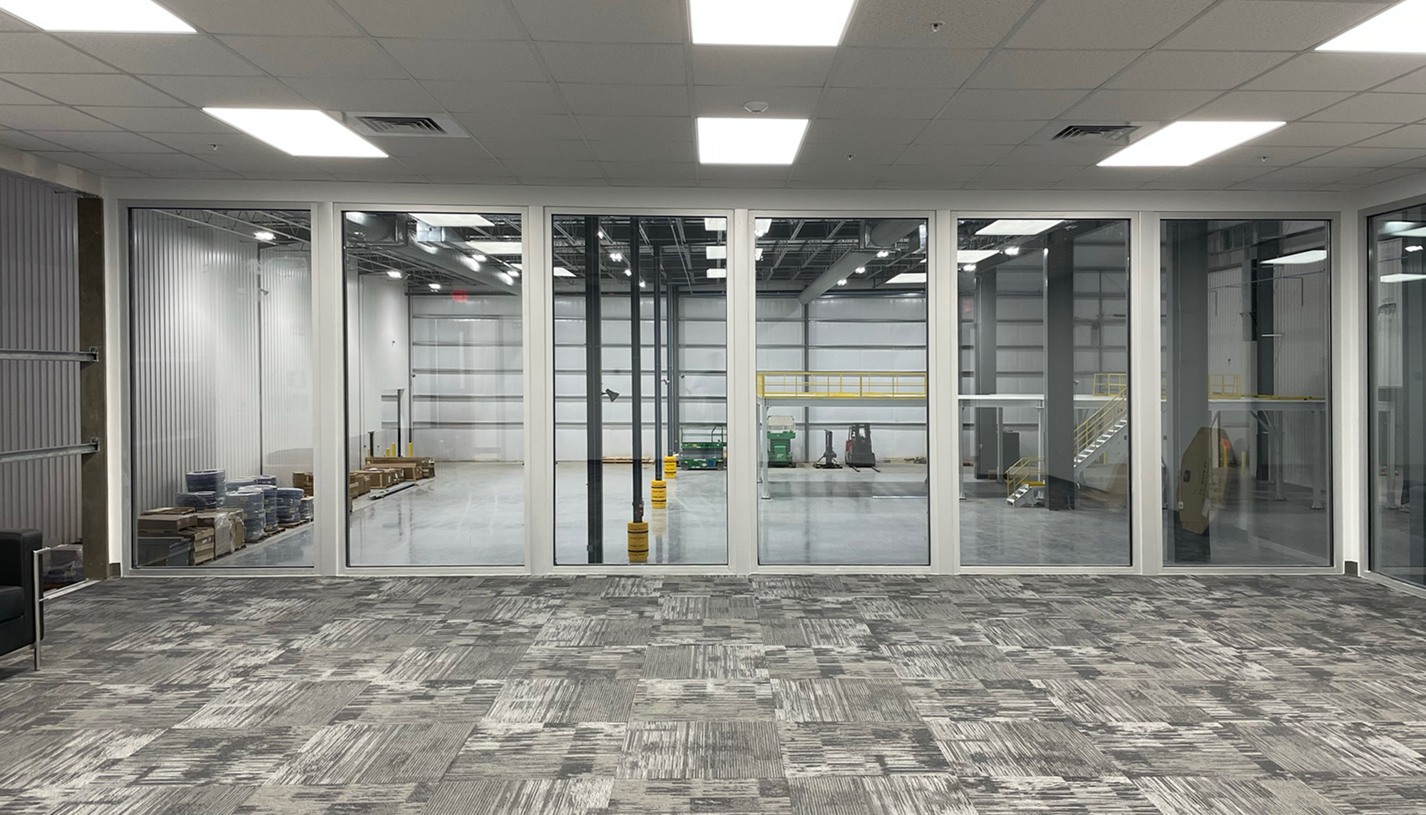 Interior office and observation area inside the Transcendia manufacturing facility featuring integrated visibility into high-bay production operations and coordinated workspace design supporting efficient manufacturing workflows.
