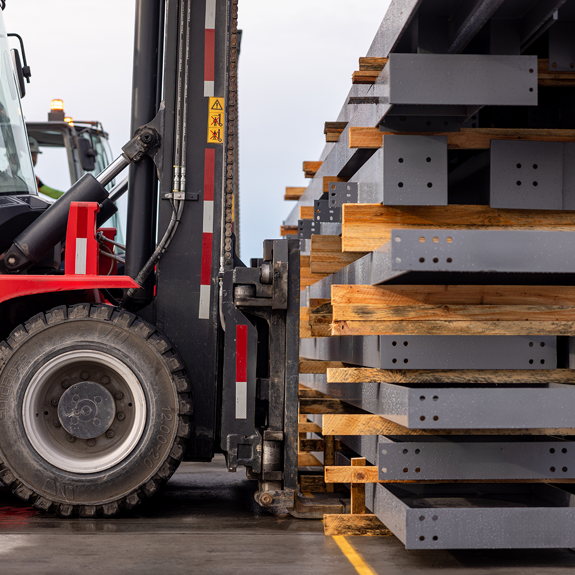 Forklift delivering pre-engineered steel panels. 