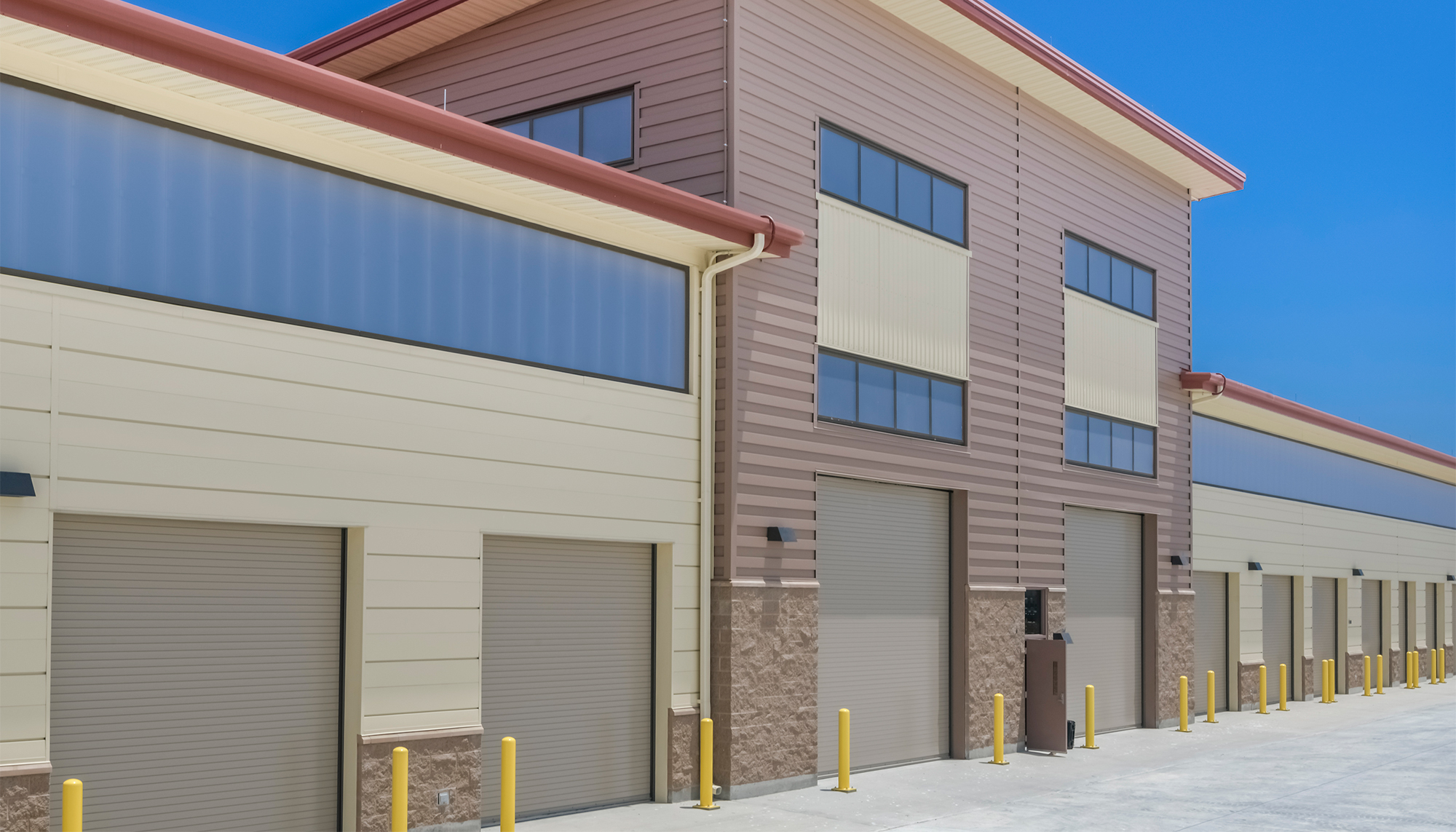 Exterior service bay area at the U.S. Navy Forklift Rework Facility featuring integrated maintenance access, administrative space and a coordinated operational environment designed to support equipment repair and training functions.