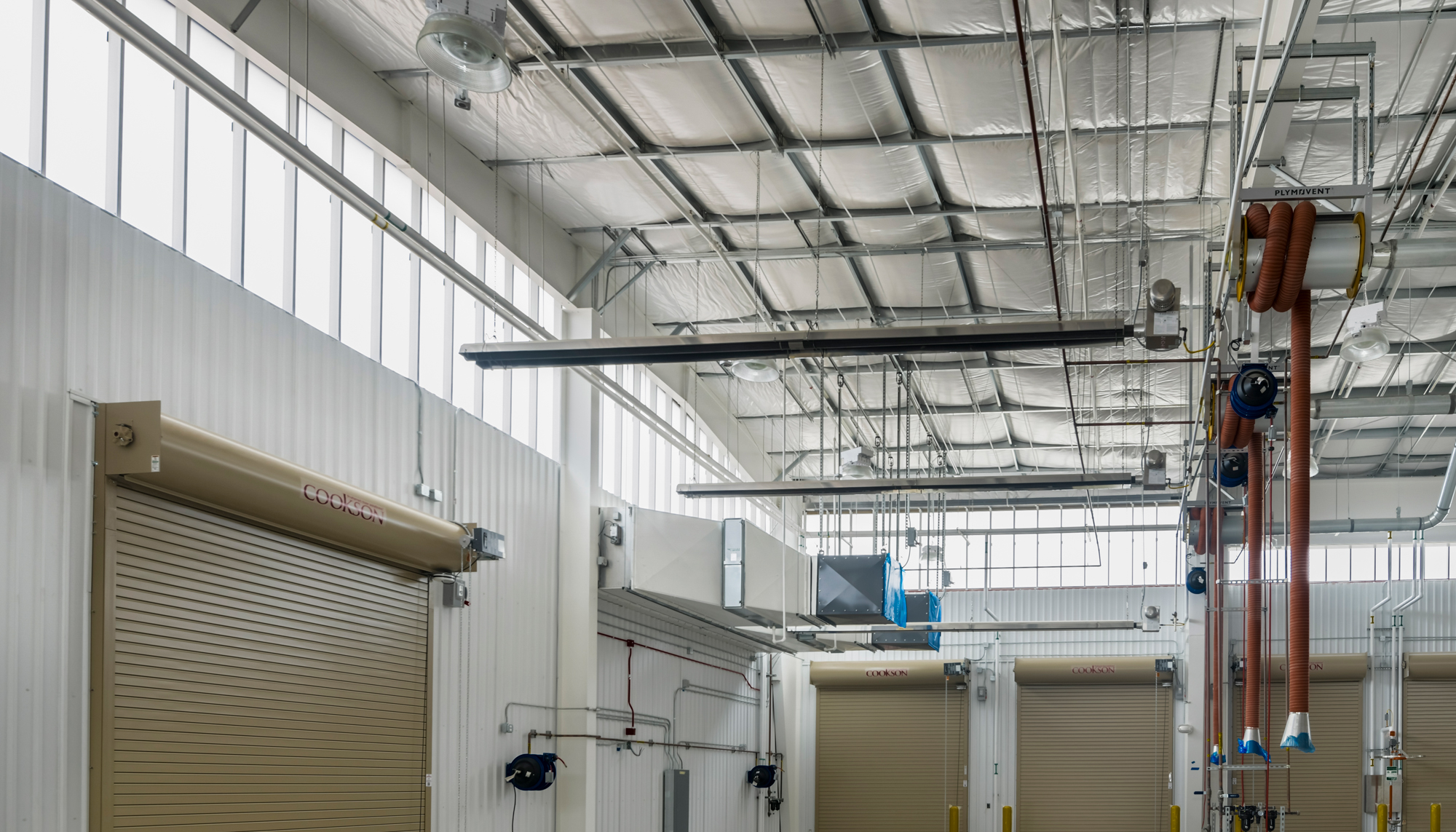 Interior operational space at the U.S. Navy Forklift Rework Facility featuring integrated overhead systems, service access points and coordinated maintenance infrastructure designed to support equipment repair and training activities.