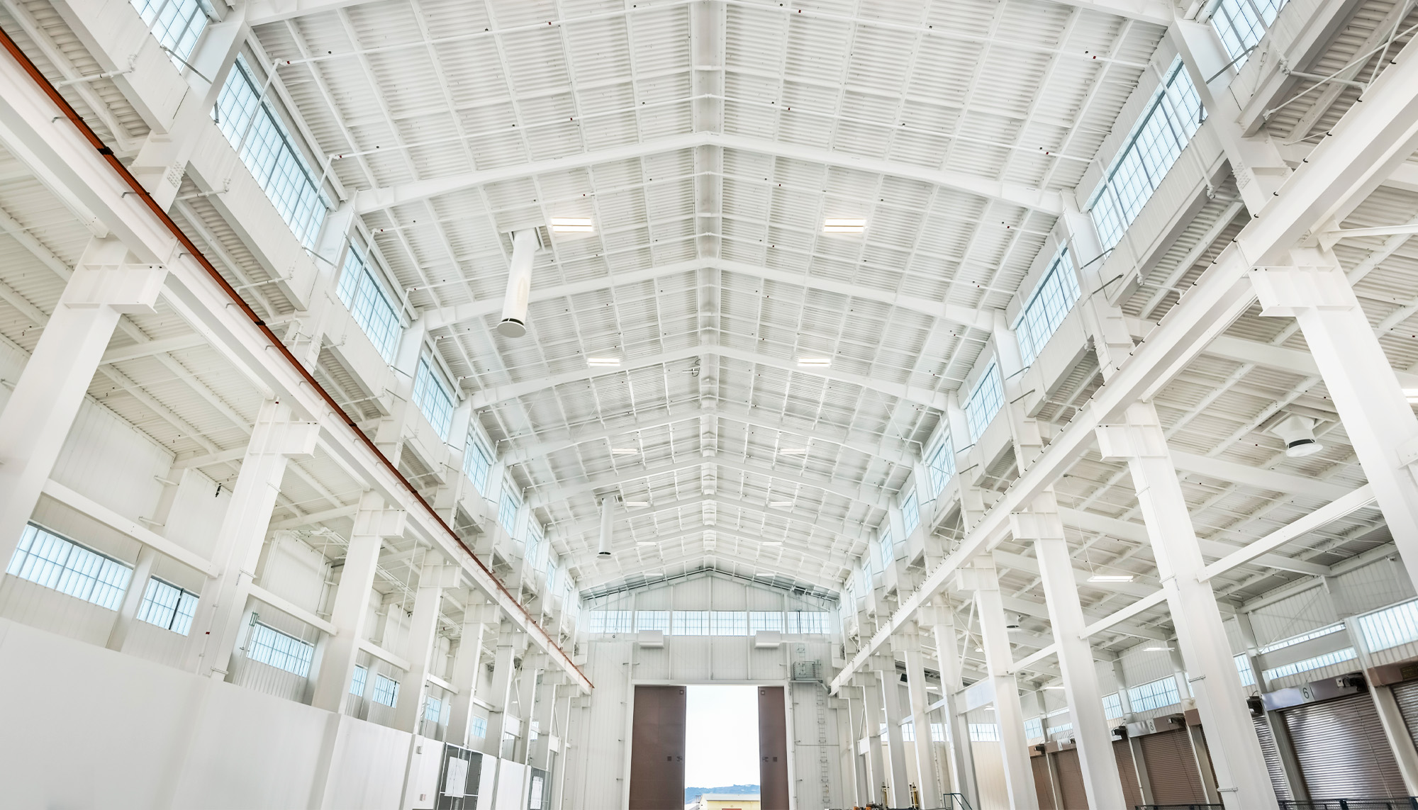 Low angle shot of Undersea Rescue Command facility interior with clear span steel framing, high-bay production space and overhead crane support structure.