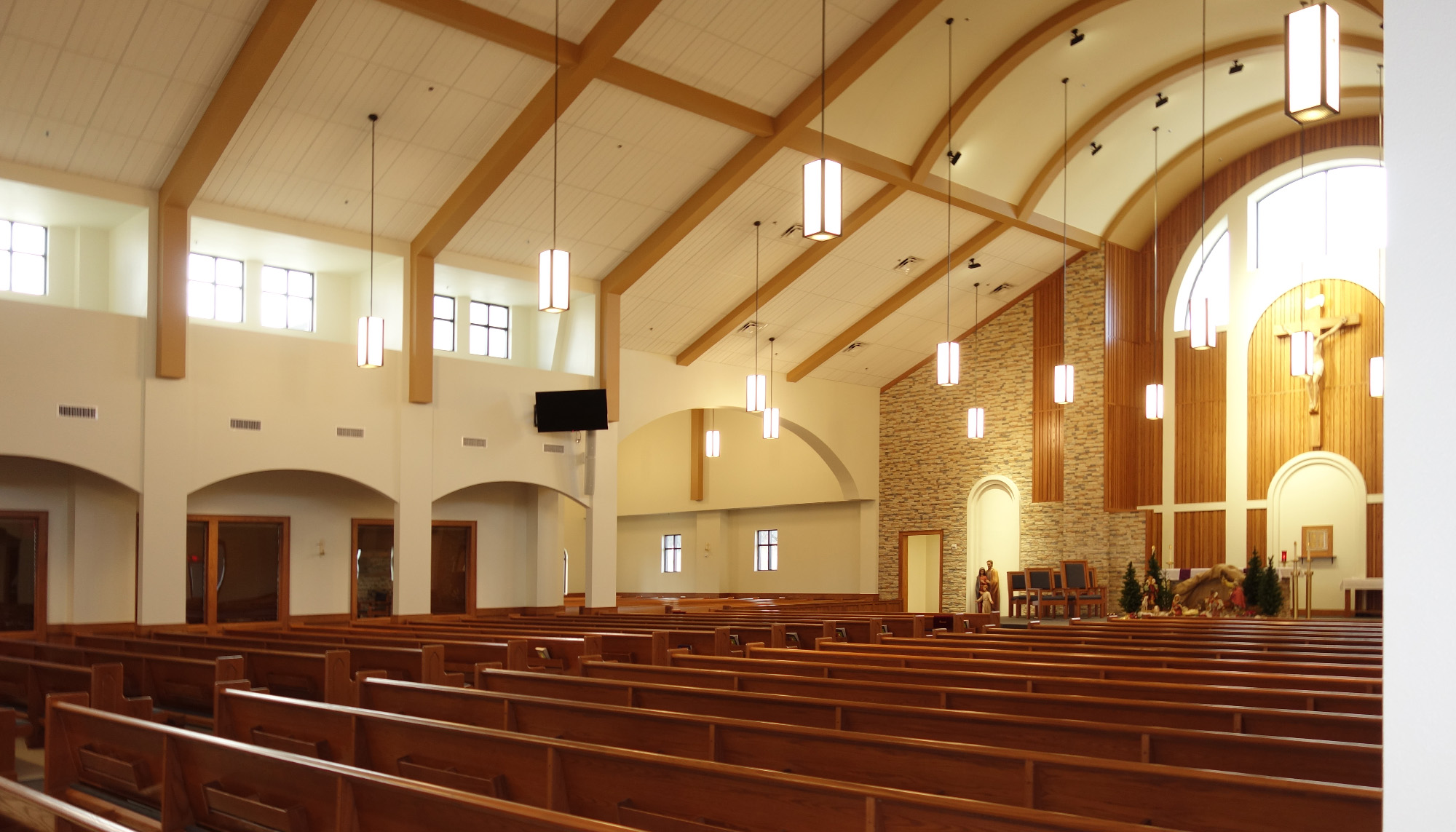 St. Thomas the Apostle Catholic Church interior with exposed timber framing, vaulted ceiling and large congregational seating area.