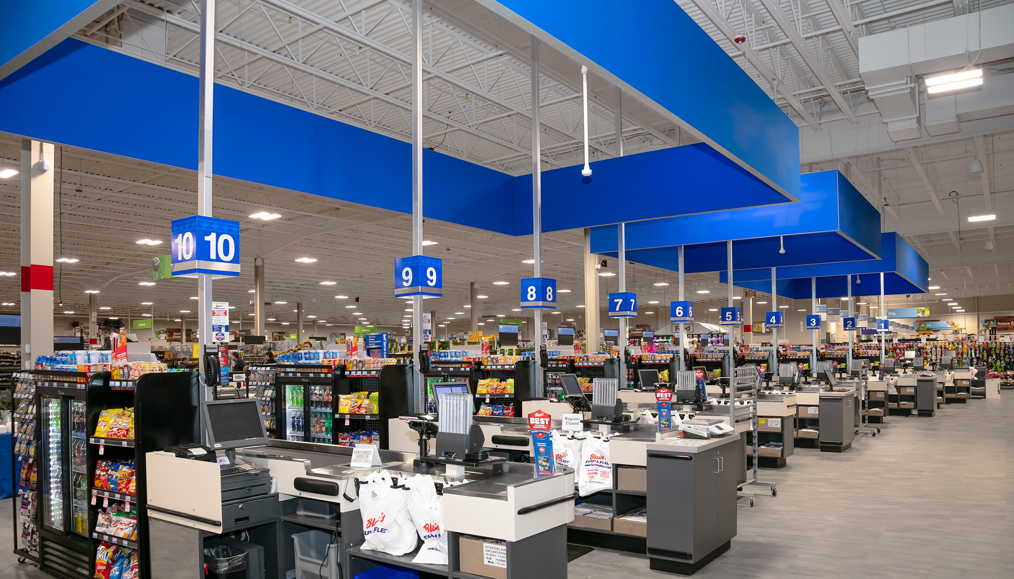 Interior checkout area at the Blain’s Farm & Fleet retail facility featuring expansive open floor space, integrated customer service stations and coordinated retail systems designed to support efficient circulation and high-volume operations.
