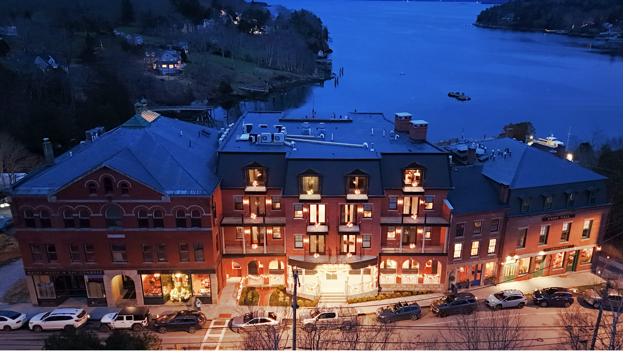 Exterior evening view of the Rockport Harbor Hotel featuring integrated historic architecture, coordinated waterfront hospitality spaces and a unified hotel environment developed to connect existing and new structures with precision and operational continuity.
