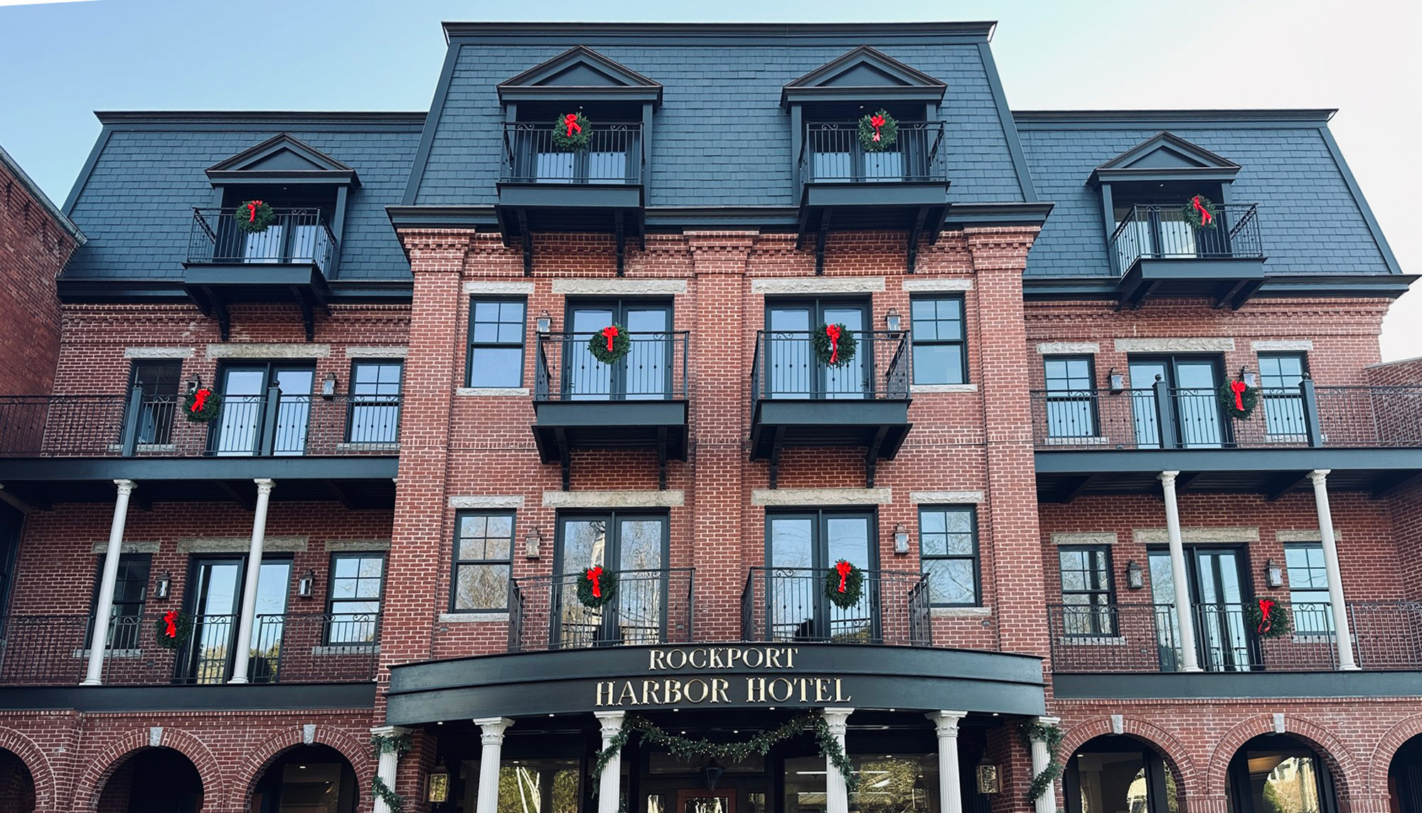 Front exterior view of the Rockport Harbor Hotel featuring integrated historic architecture, coordinated hospitality spaces and a unified waterfront hotel environment developed to connect new and existing structures with precision and long-term performance.