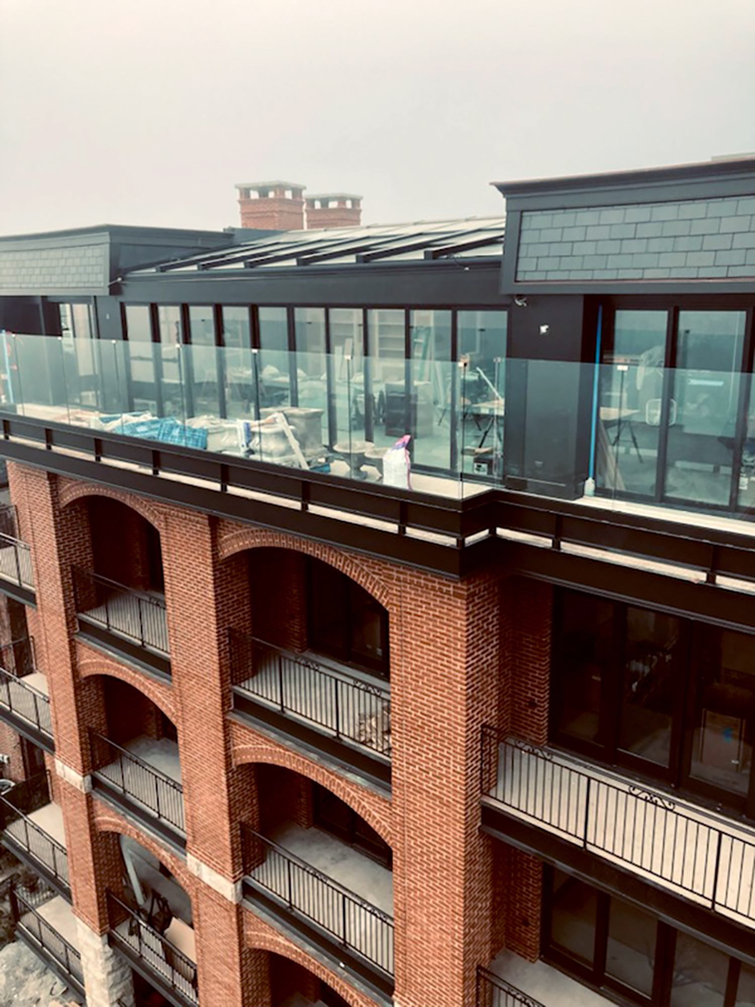 Exterior architectural detail of the Rockport Harbor Hotel featuring integrated balcony and terrace spaces, coordinated historic façade elements and a unified hospitality environment developed to connect new and existing waterfront structures seamlessly.