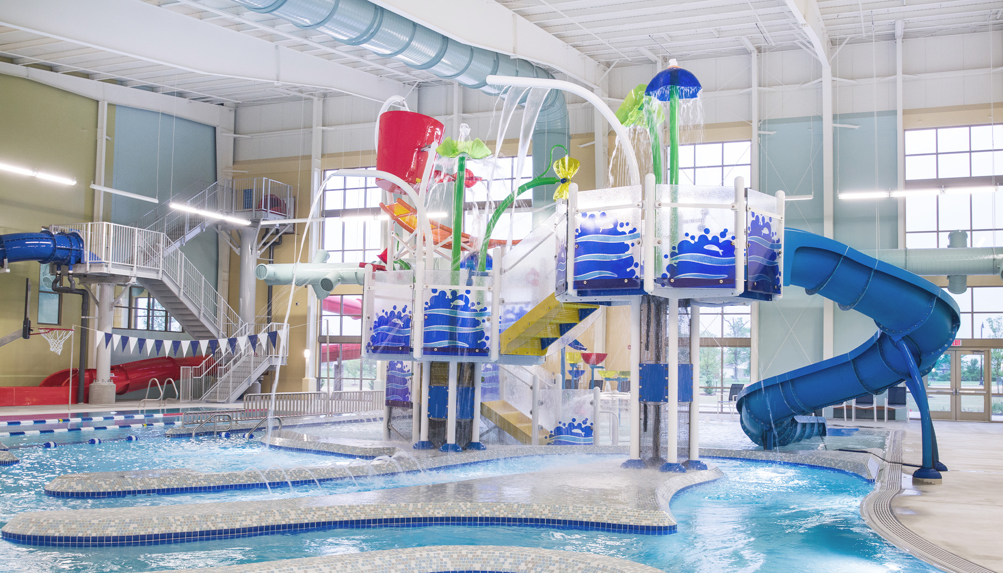 Indoor water park featuring clear span steel framing, aquatic play structures and commercial recreation facility design.