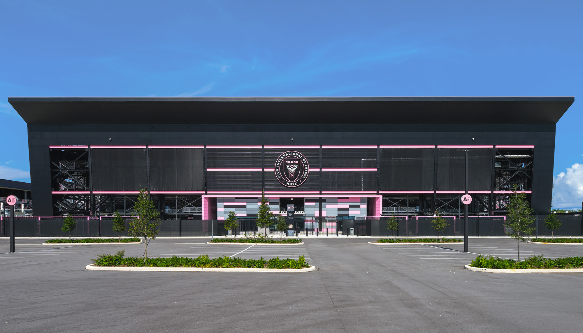 Inter Miami CF training center with steel building construction, modern athletic facility design and illuminated glass facade.