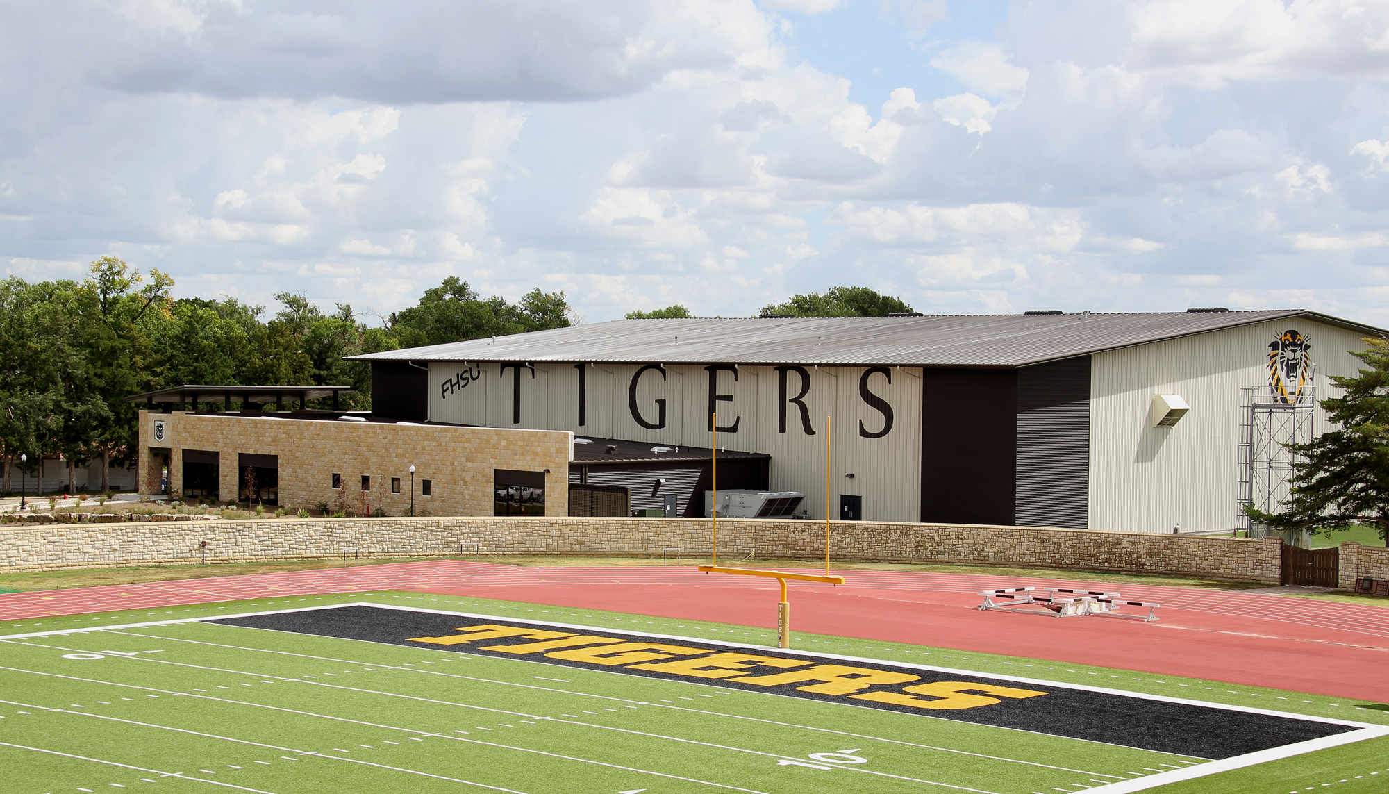 Exterior view of the Fort Hays State University Indoor Practice Facility featuring integrated campus architecture and adjacent athletic field access.