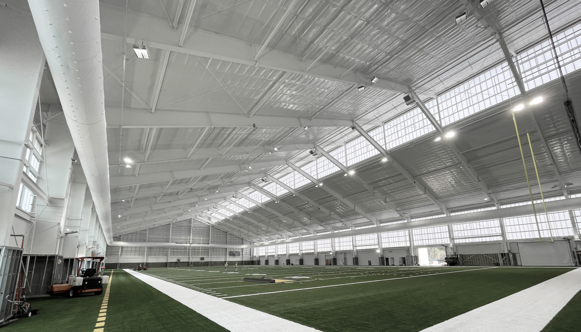Interior corner view of the Jacksonville Jaguars Indoor Practice Facility featuring expansive indoor training space, integrated daylighting systems and coordinated athlete performance environments designed to support year-round team operations and recovery.