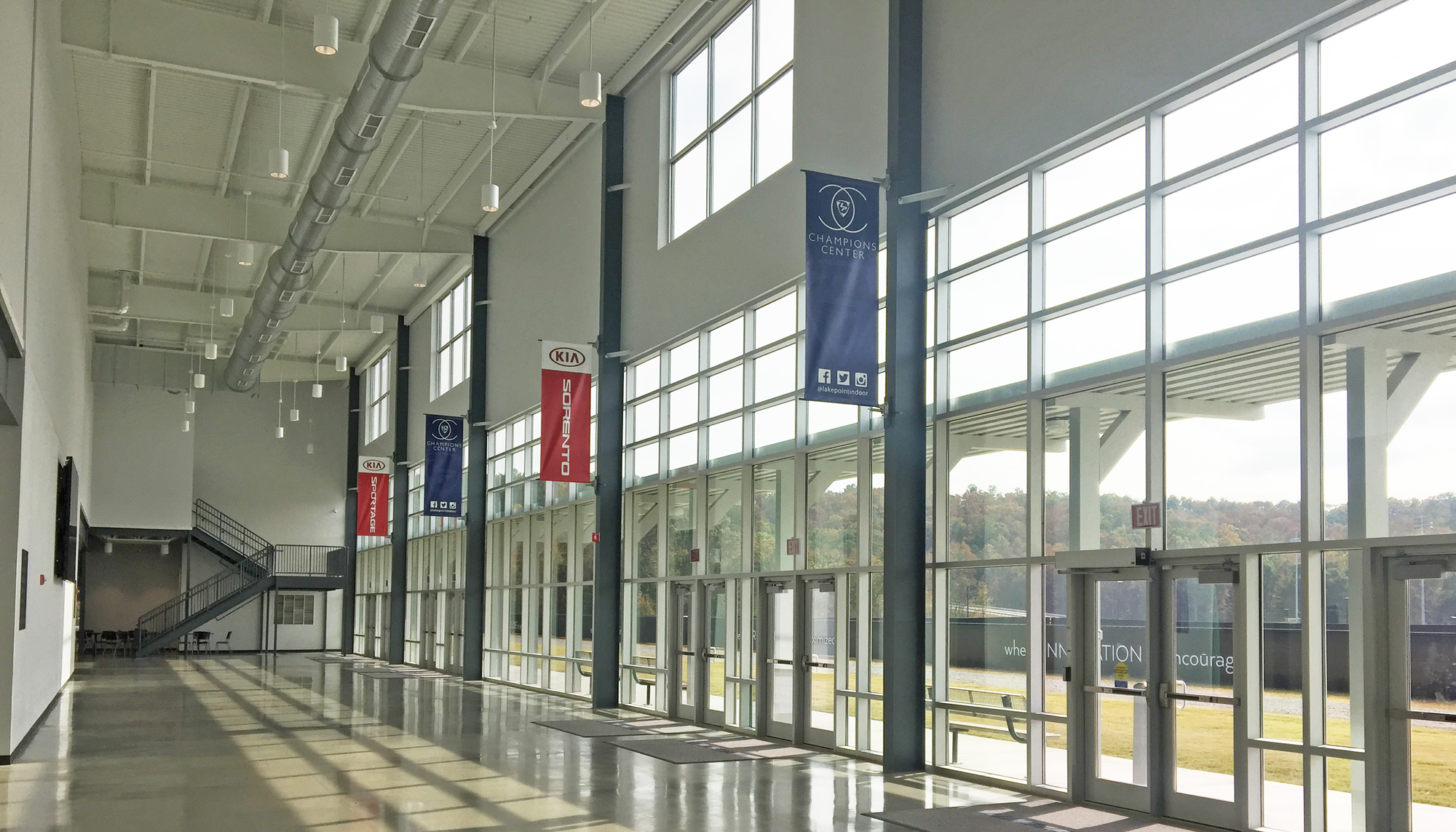 Interior concourse at the LakePoint Sports Champions Center featuring expansive glazing, elevated circulation space and integrated access to multiple indoor athletic courts.