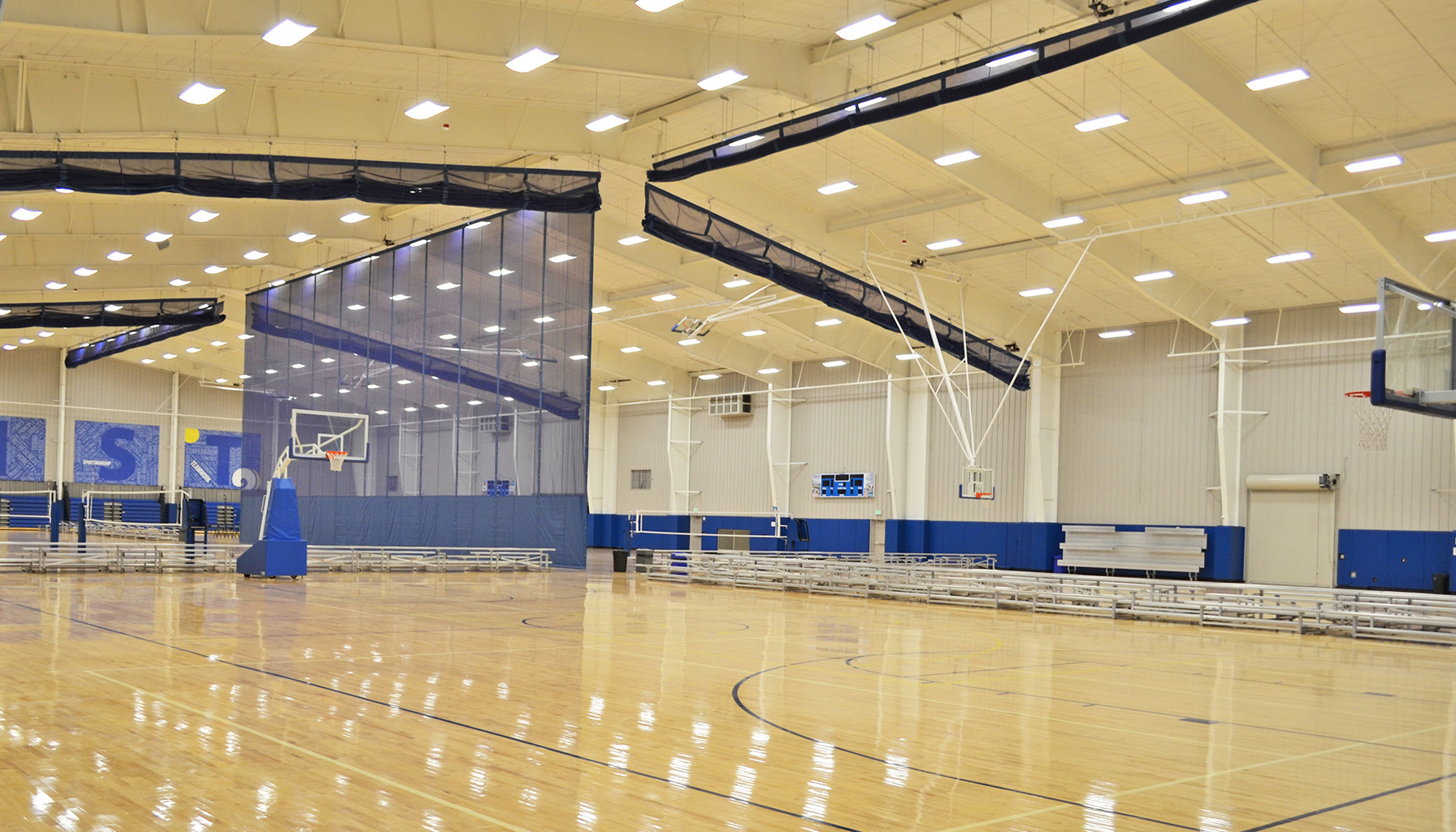 Sports complex interior with structural steel framing, basketball courts and large-span recreation facility construction.