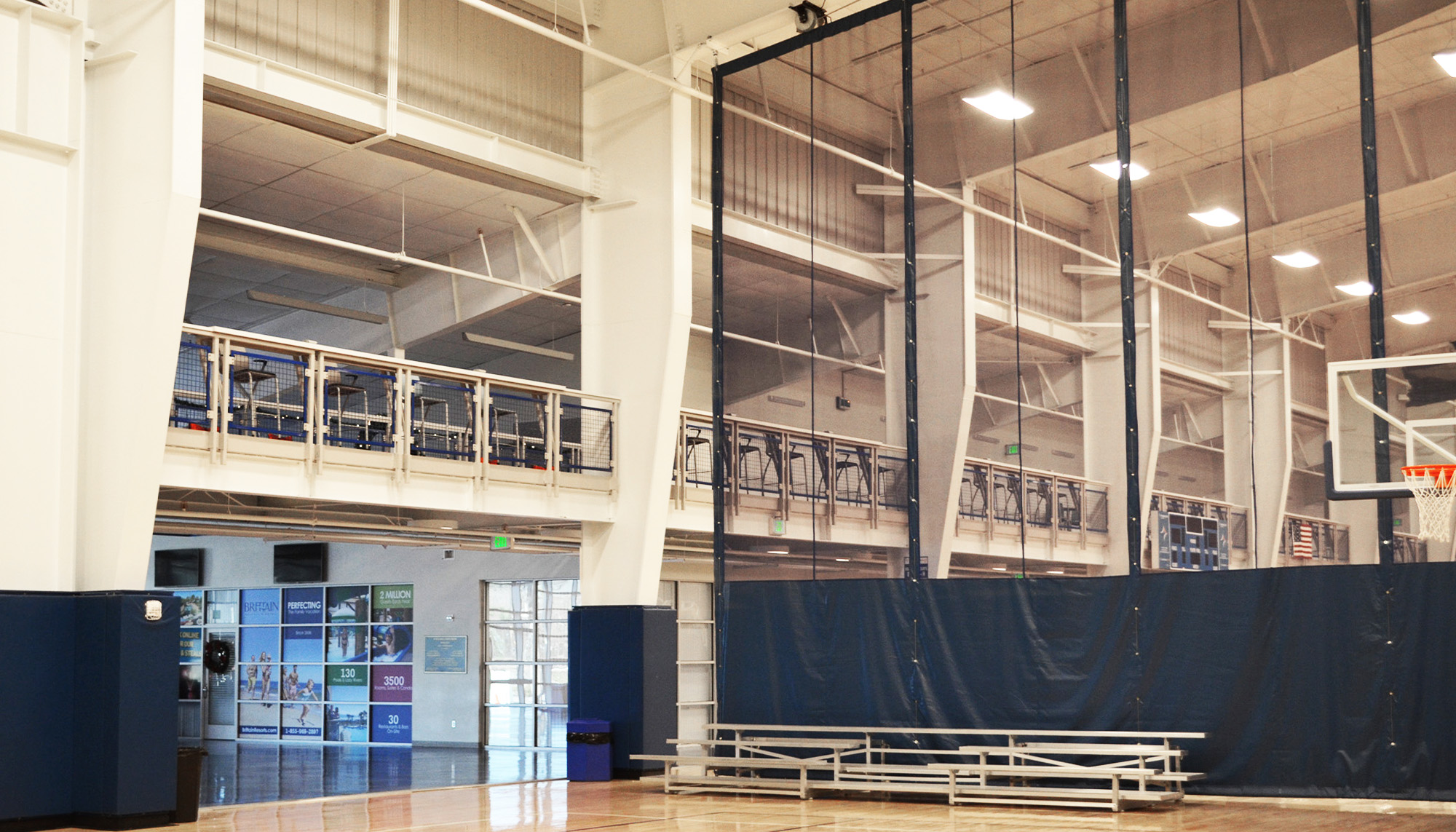 Indoor sports complex featuring clear span steel framing, elevated spectator viewing area and multi-court athletic facility design.